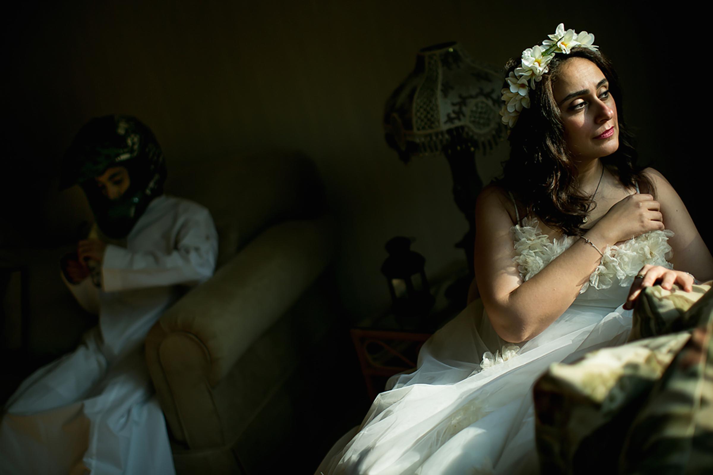 Mai sits in her wedding dress that she wore 15 years ago while her son sits in the background in Jeddah, October 2015. "I married my college classmate in dental school. Sharing two children and a happy marriage, we finally decided to buy our dream house. Two days before signing the lease, he died in a motorcycle accident. Then, my father died. I was legally required to have a male guardian. I now wait for my son to turn 16 to take that role. Until then, my half brother decides on my behalf."