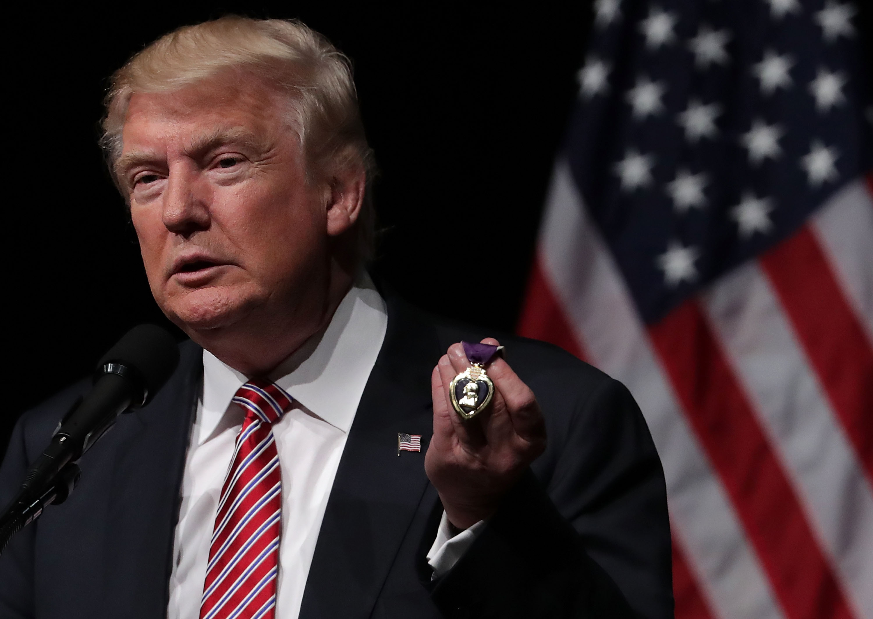 Republican presidential nominee Donald Trump holds a Purple Heart, given to him by veteran Louis Dorfman, during a campaign event at Briar Woods High School in Ashburn, Va., on Aug. 2, 2016.