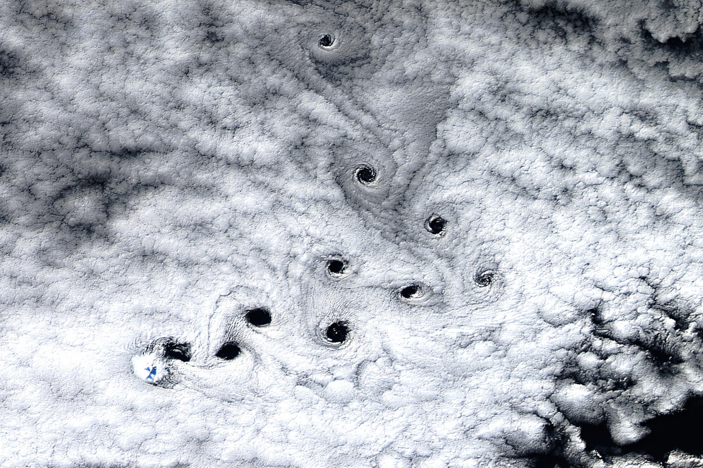 When the Operational Land Imager (OLI) on Landsat 8 captured this image of Heard Island, just the tip of Mawson Peak—the highest point on the island—was visible through the sheet of marine stratocumulus clouds swirling over this part of the Furious Fifties. Though just 2,745 meters (9,006 feet), the mountain was tall enough to stir up several cloud vortices that swirled downwind like eddies in a fast-moving river, May 3, 2016.