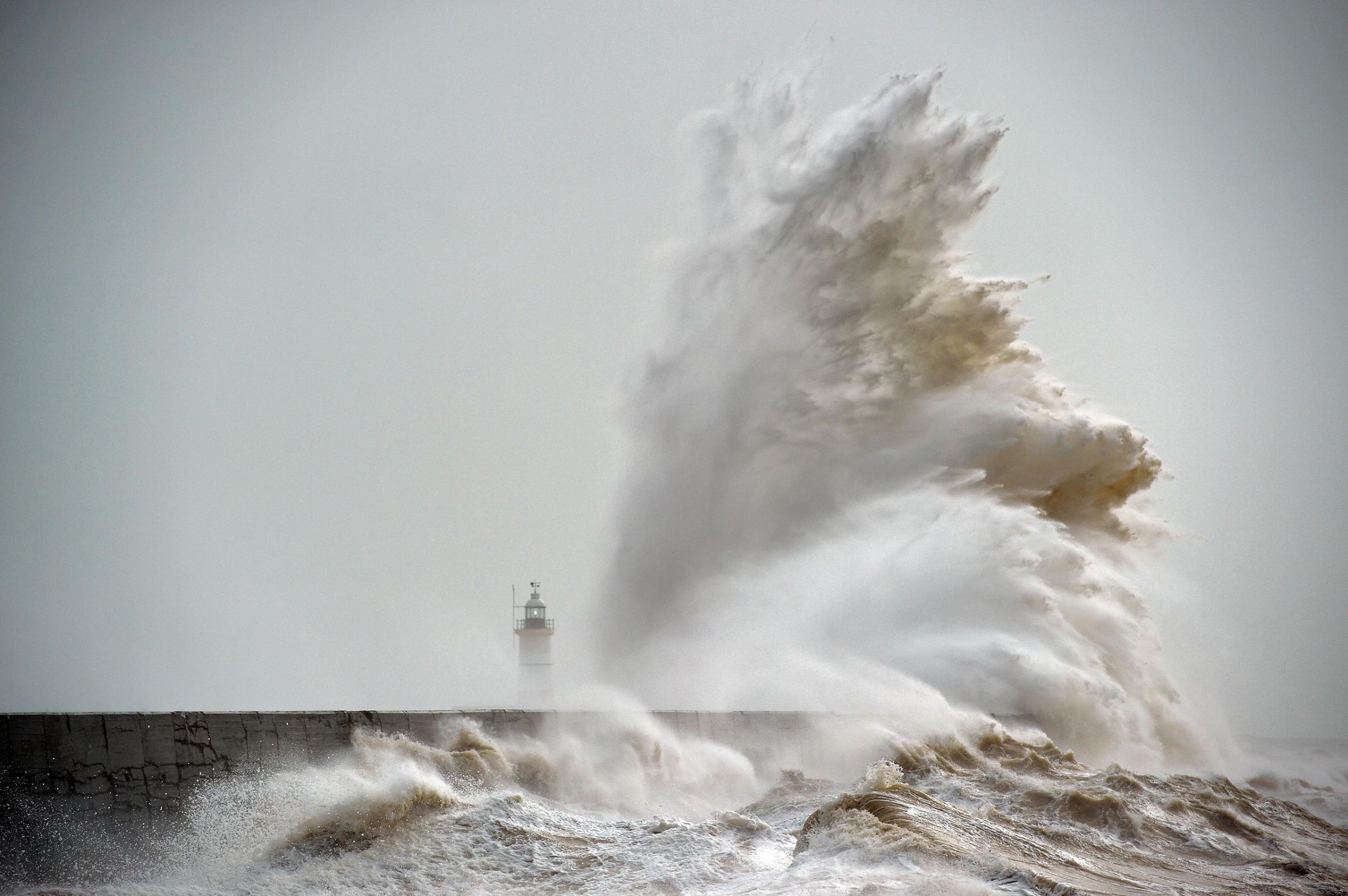 Waves crash over Newhaven Lighthouse on the south coast of England on Feb. 8, 2016.
