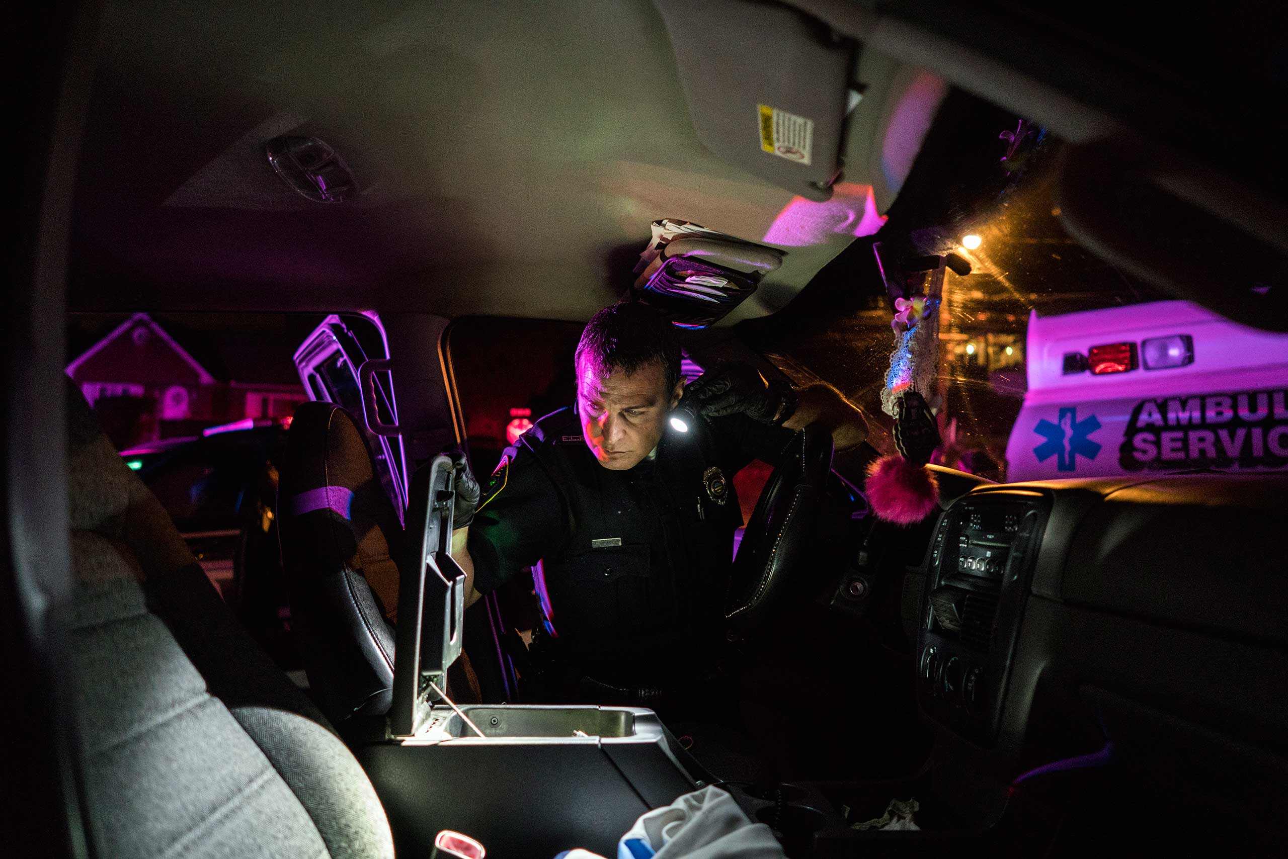 Patrolman John Headly searches through the car of a young man arrested for heroin possession in East Liverpool, Ohio, on Oct. 7, 2016. A small child safety seat was strapped into the back seat with a syringe nearby.