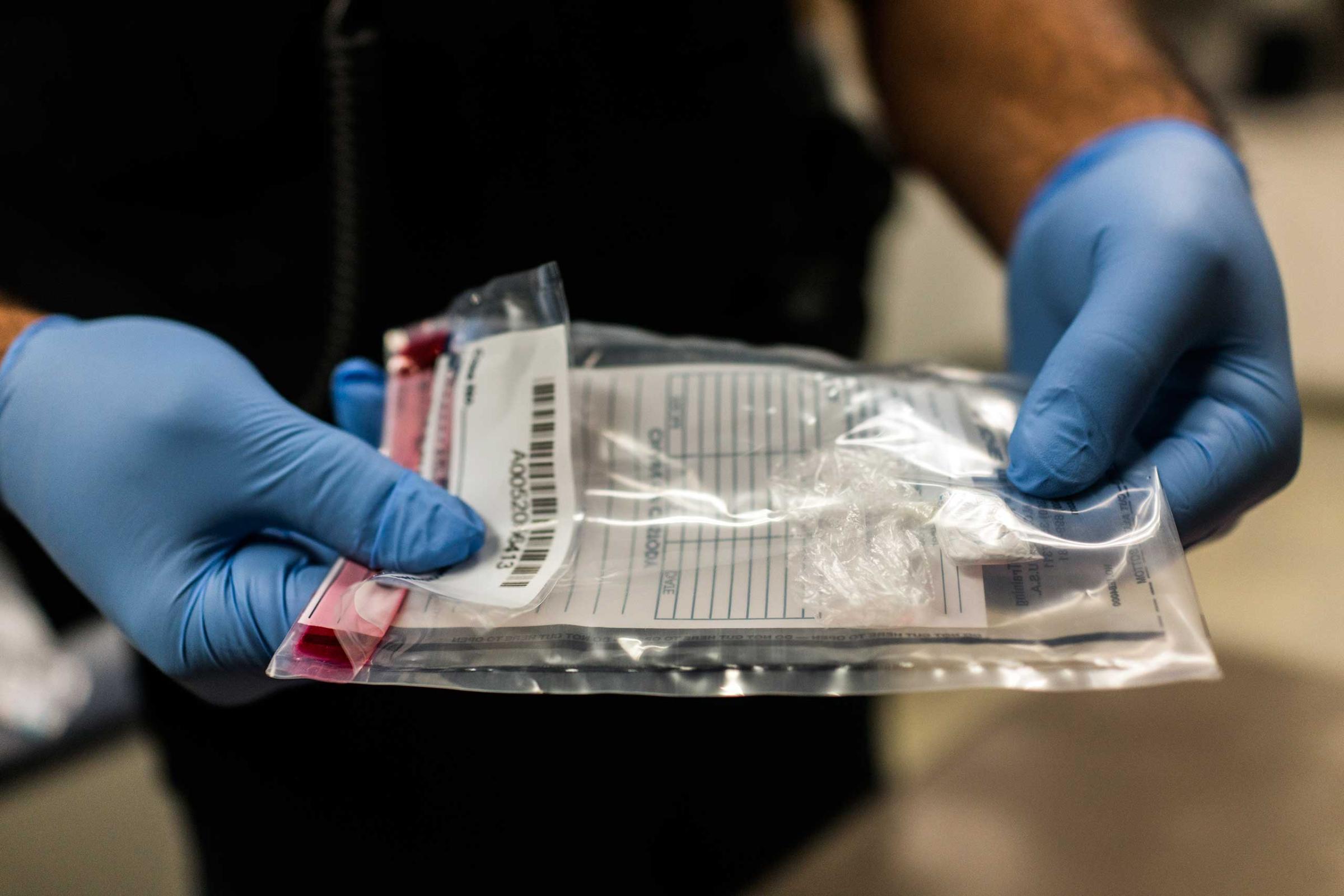 An East Liverpool police officer shows an evidence bag filled with heroin on Oct. 7, 2016. "We can't even touch these things anymore," he said. "These drugs are cut with so much Fentanyl that one touch, one breathe, would kill most men."