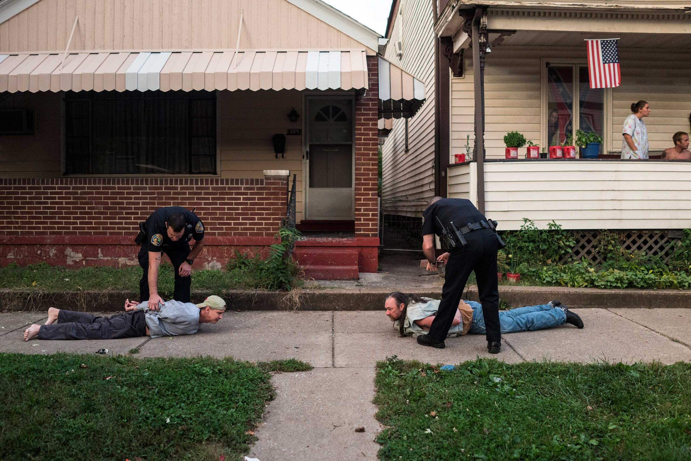 Officers arrest two men after an apparent an assault as neighbors watch in East Liverpool, Ohio, on Oct. 8, 2016.
