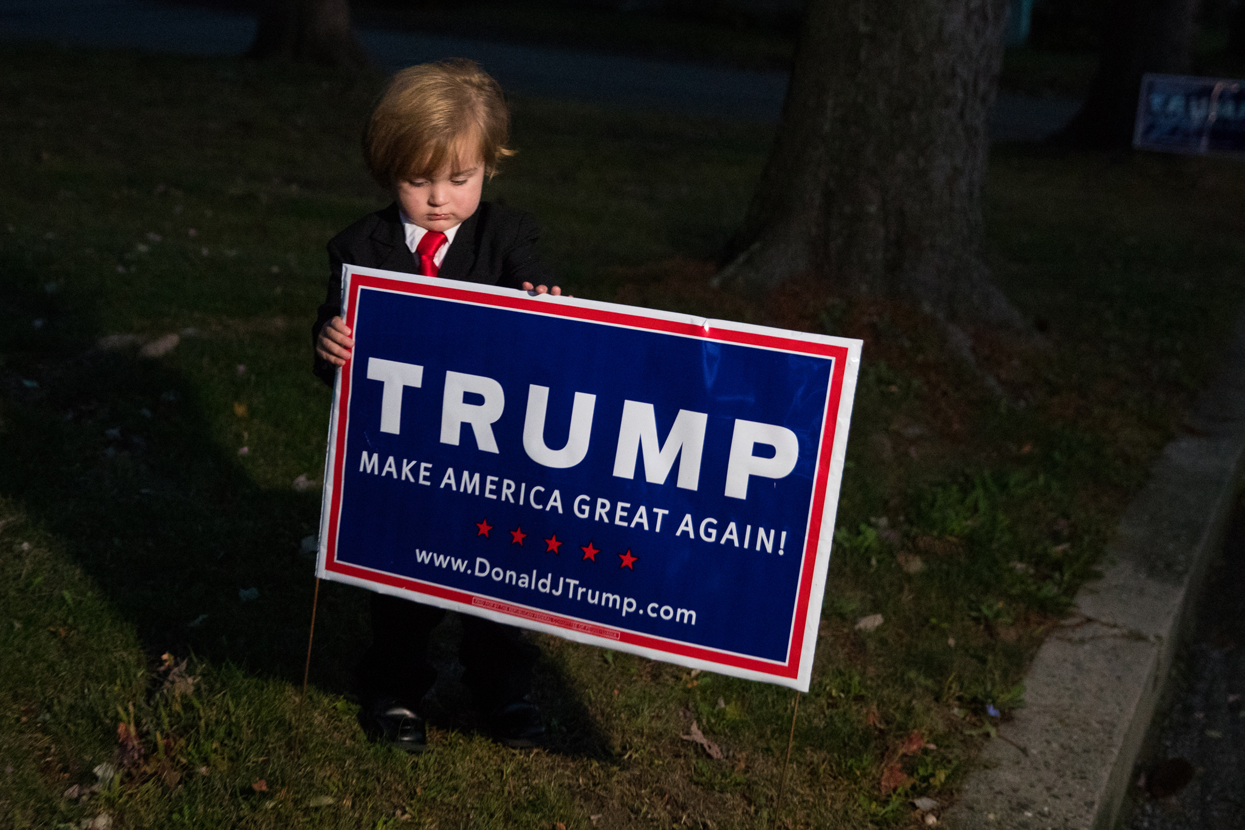 Hunter Tirpak, 2, is dressed as Donald Trump as he adjusts a campaign sign outside his home in Tuscarora, Pa., on Oct. 12, 2016.