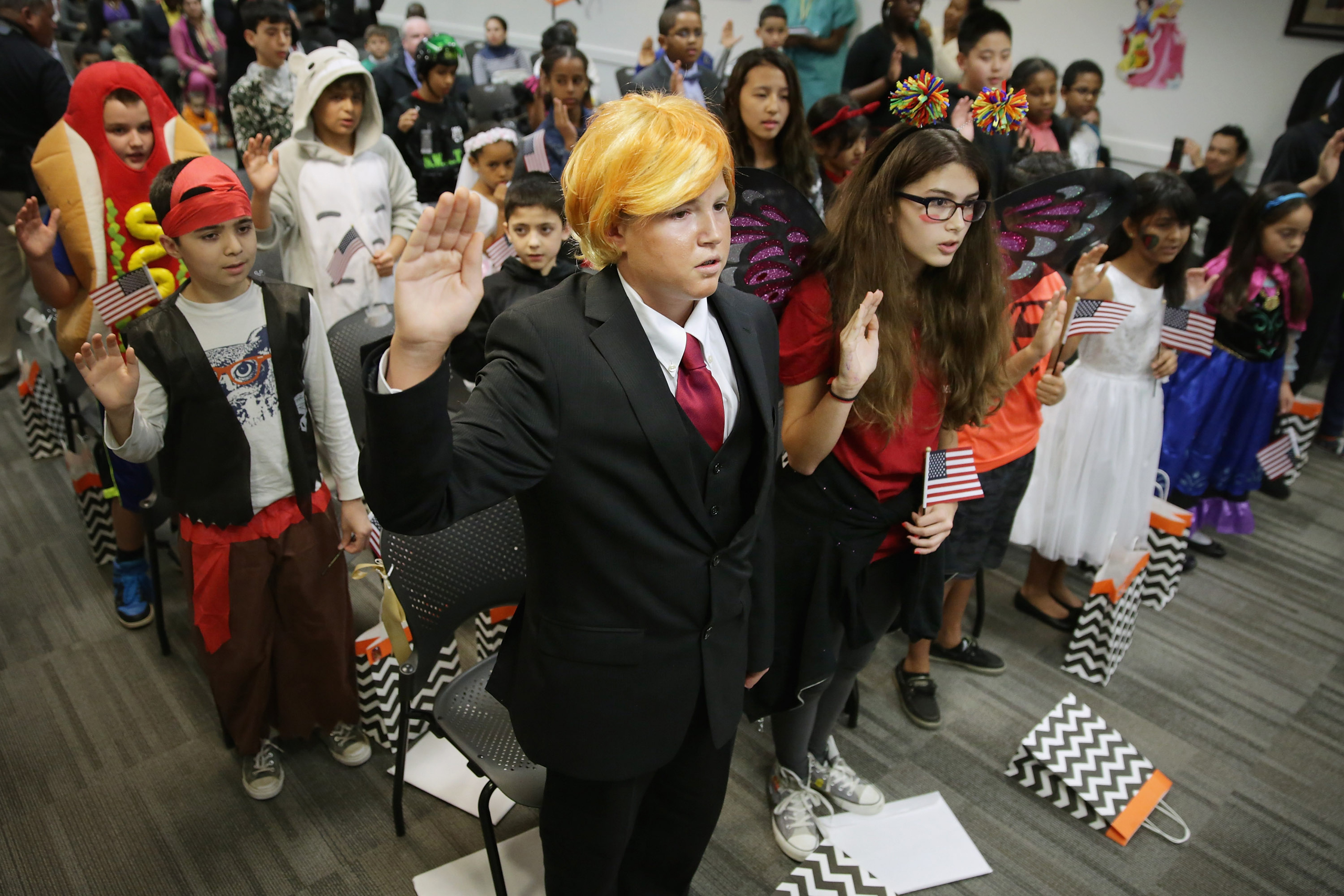 Dressed as  Donald Trump, 13-year-old Razvan Godja (C) and 26 other children wear Halloween costumes as they take the Oath of Allegiance during their naturalization ceremony at the U.S. Citizen and Immigration Services Washington Field Office on Oct. 30, 2015. Godja, who was born in Romania, and the other children became some of the United States' youngest and newest citizens on the day before heading out for the American tradition of trick-or-treating.