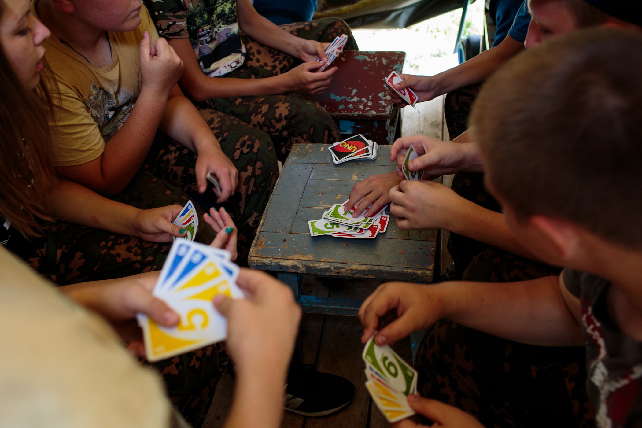 Students play a game of UNO in their tent between drills.