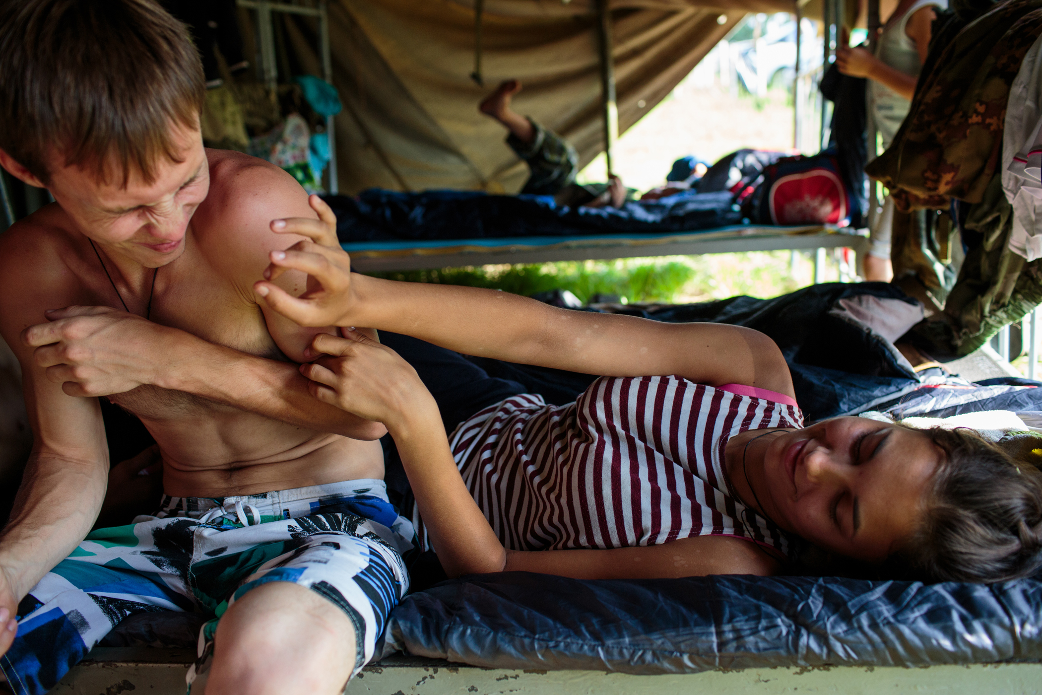 Oleg Shaula and his girlfriend Nadya Gross from Stavropol relax in a tent during the first day of the hand-to-hand combat competition at the "Orthodox Warrior" camp.