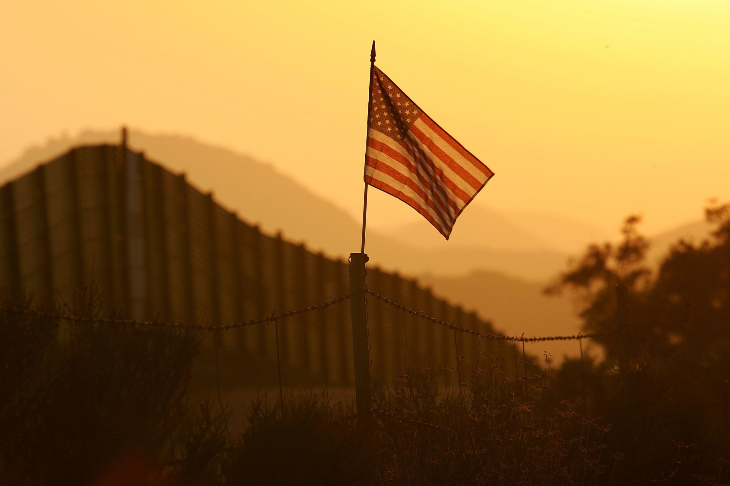 A U.S. flag put up by activists who oppose illegal immigration flies near the US-Mexico border fence near Campo, California, on Oct. 8, 2006.