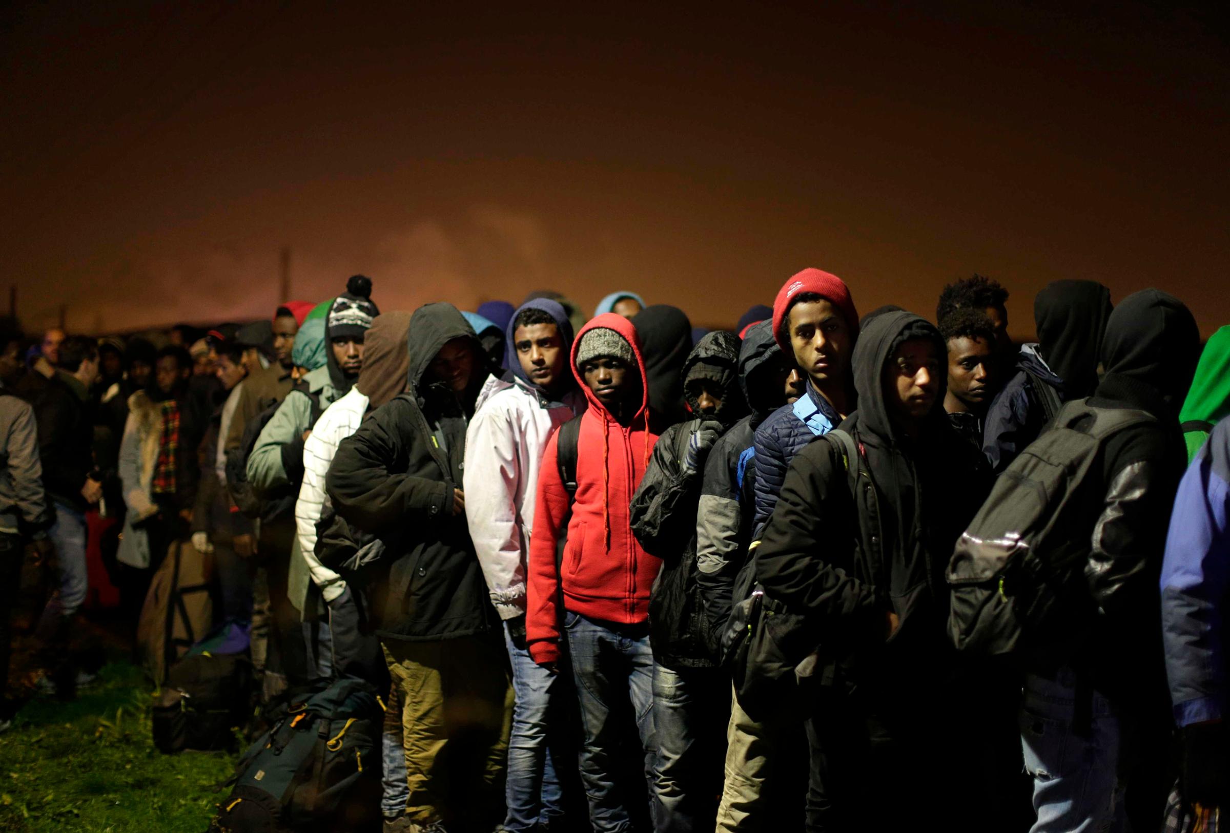 Migrants line up to register at a processing center in the makeshift migrant camp known as "the Jungle," near Calais, northern France, on Oct. 24, 2016.