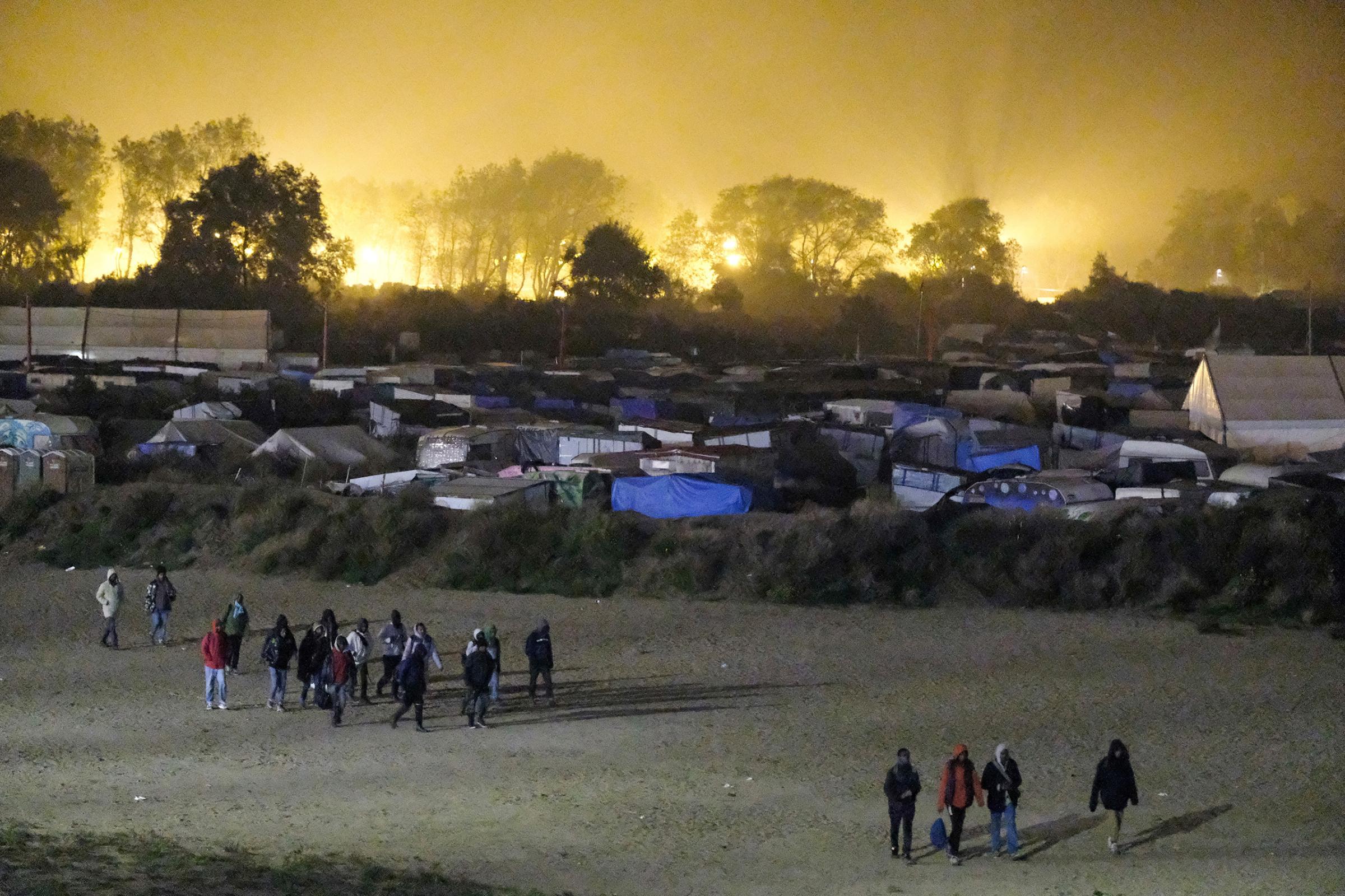 Migrants begin to leave the squalid "Jungle" camp, which authorities began to dismantle this week in a bid to move thousands of inhabitants elsewhere, in Calais, northern France, on Oct. 24, 2016.
