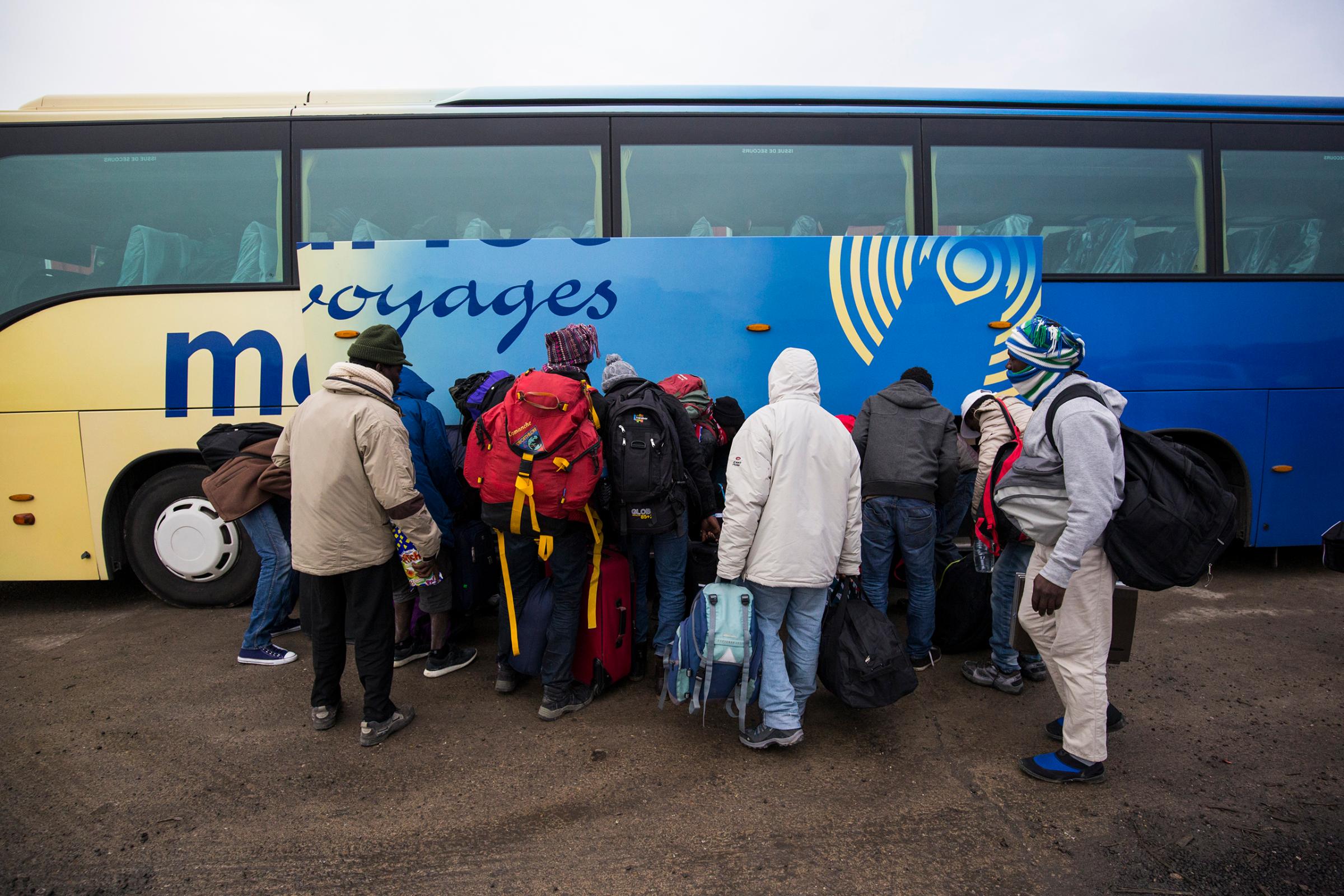 Migrants board buses outside the "Jungle" migrant camp dismantled this week by authorities, headed to refugee centers around France, at a reception point in Calais on Oct. 24, 2016.