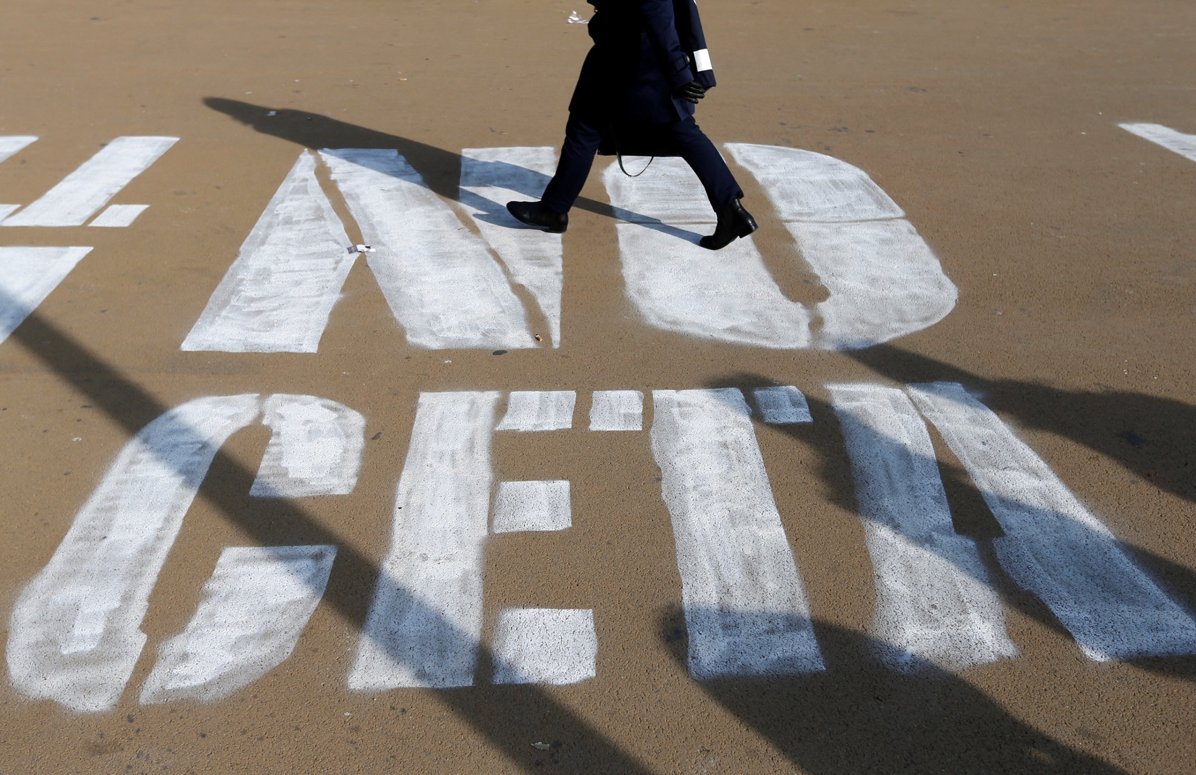 A woman walks on a graffiti reading "NO CETA", referring to the Comprehensive Economic and Trade Agreement, in Brussels, Belgium, October 13, 2016. REUTERS/Francois Lenoir - RTSS28H