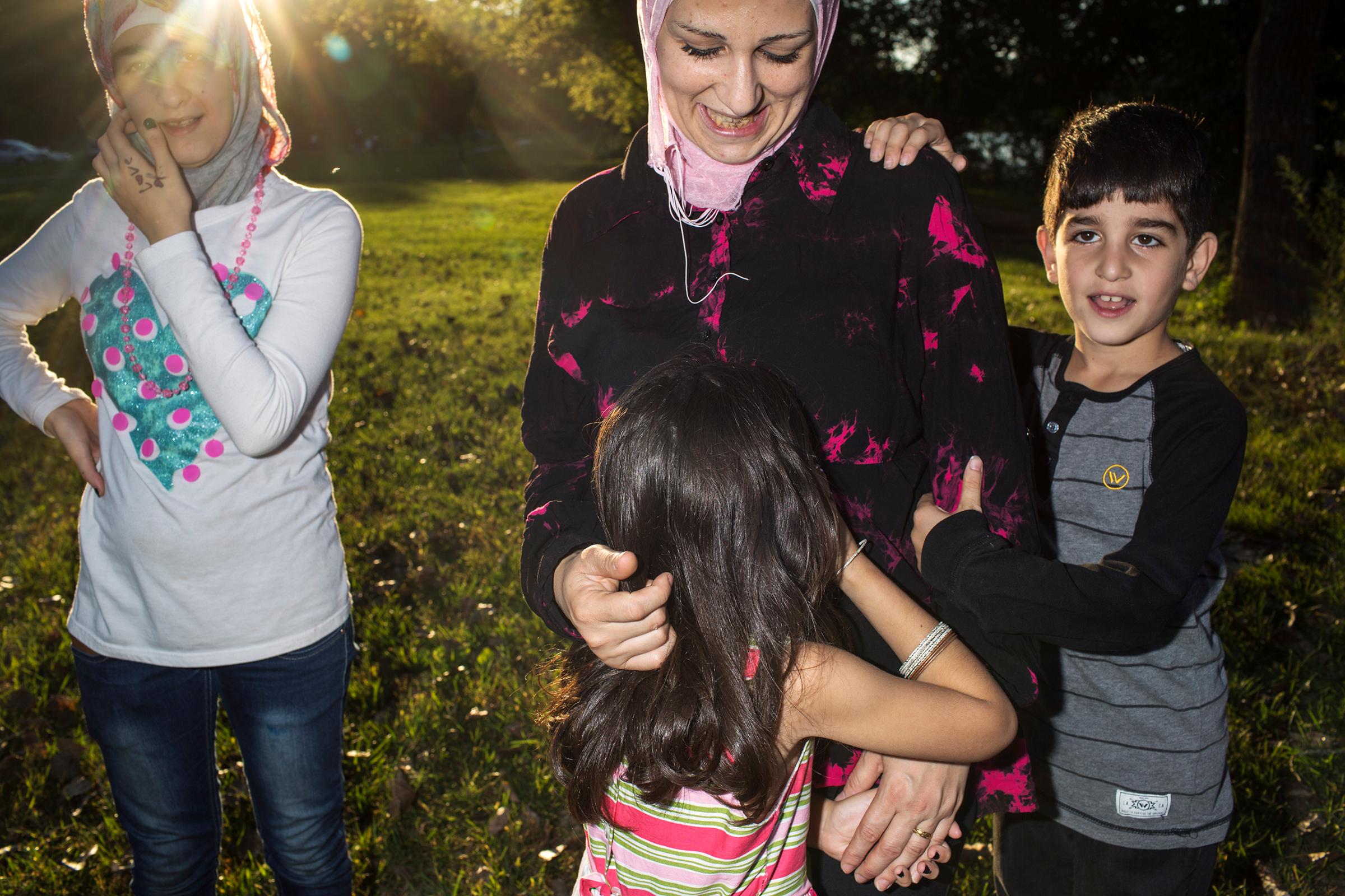 Ghazweh plays with her children Sedra, Hala and Mutaz at a park in Des Moines, Iowa.