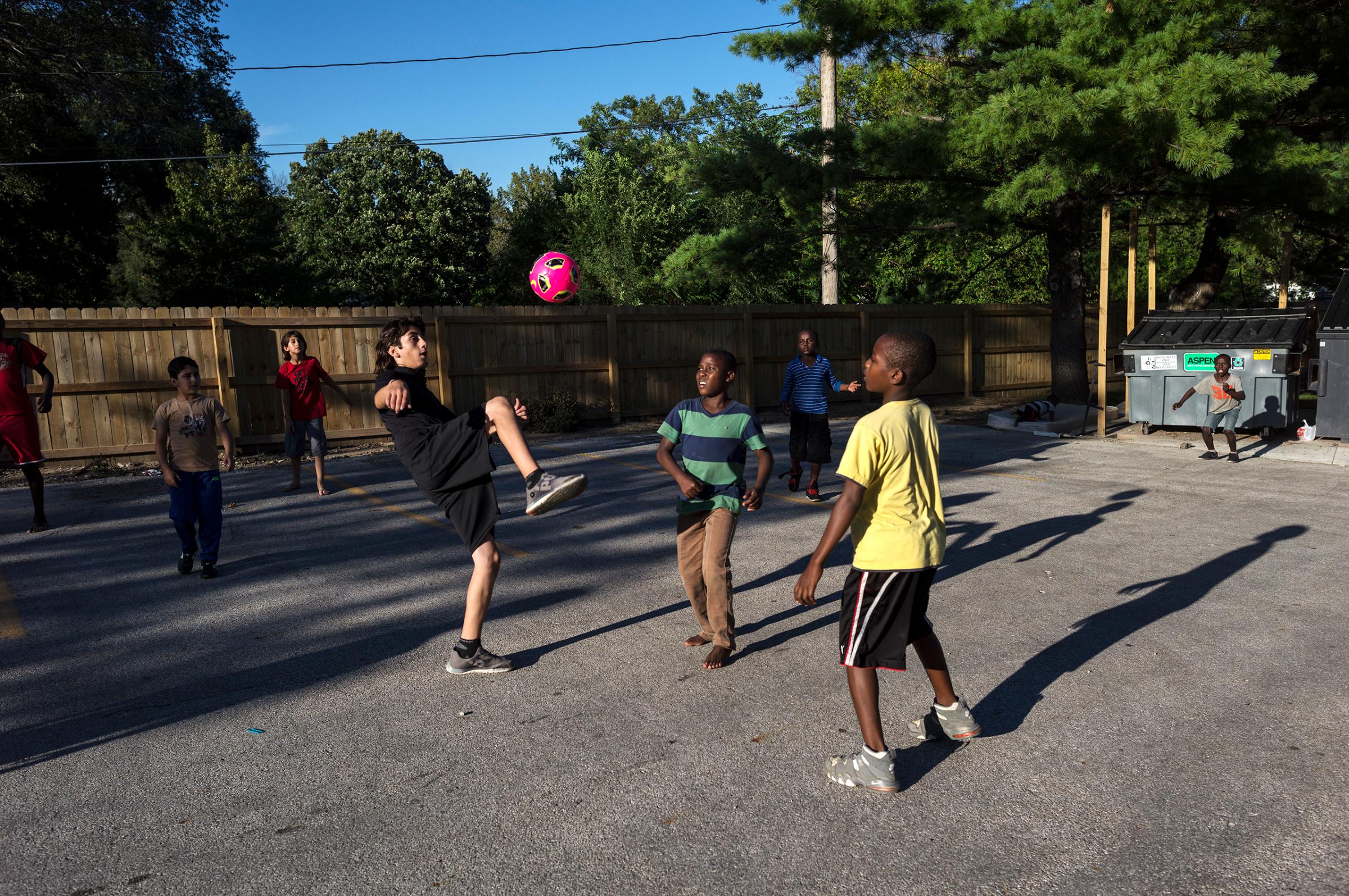 Nazeer Tameem plays soccer with other residents of the apartment complex where other refugee families have been settled.