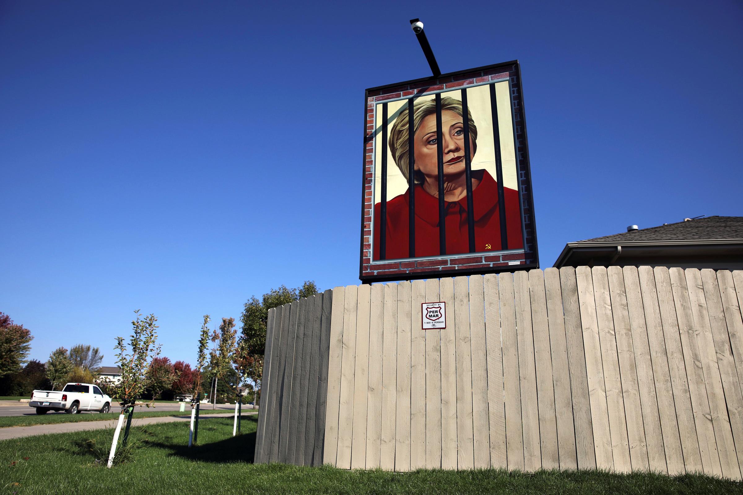 A poster depicting U.S. Democratic presidential candidate Hillary Clinton behind bars hangs in the yard of George Davey in West Des Moines, Iowa