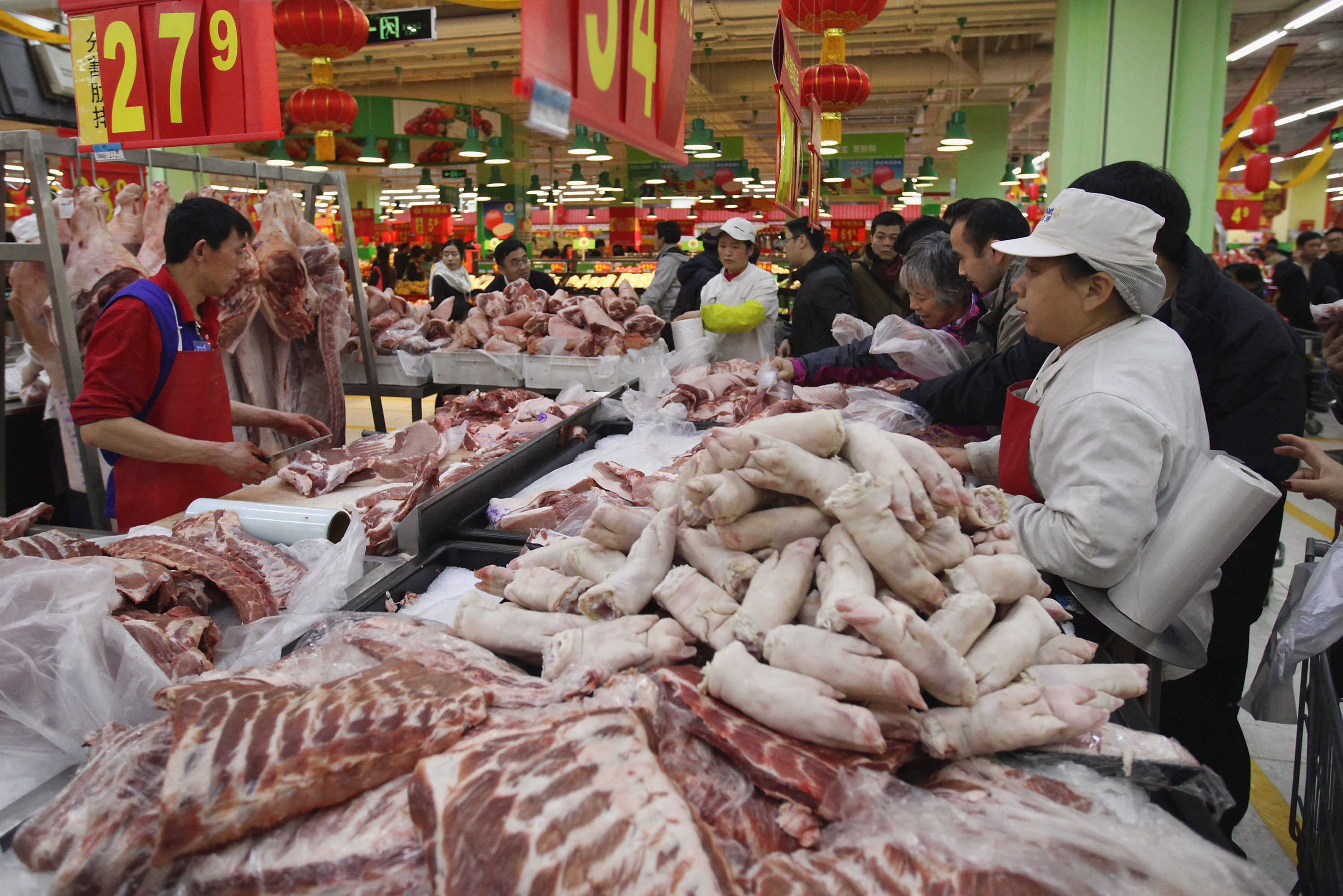 Chinese people buy pork for the Lunar New Year's Eve dinner in a Wal-Mart neighborhood market on January 21, 2012 in Beijing, China. (Feng Li—Getty Images)