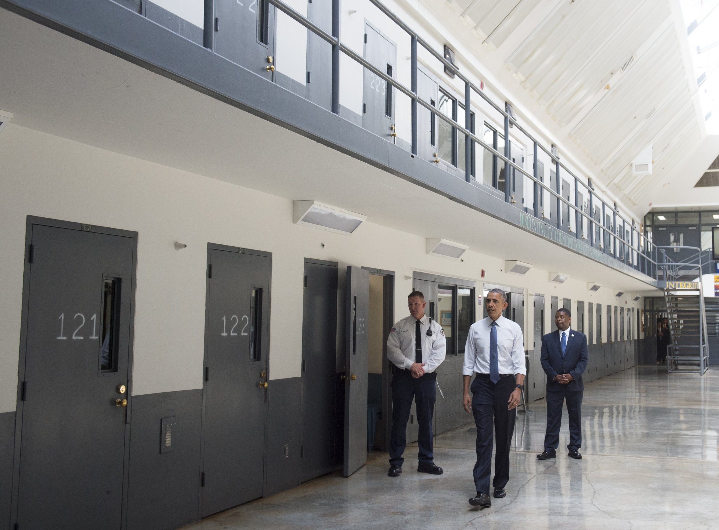 Barack Obama, alongside Charles Samuels (R), Bureau of Prisons Director, and Ronald Warlick (L), a correctional officer, tours a cell block at the El Reno Federal Correctional Institution in El Reno, Oklahoma, July 16, 2015.