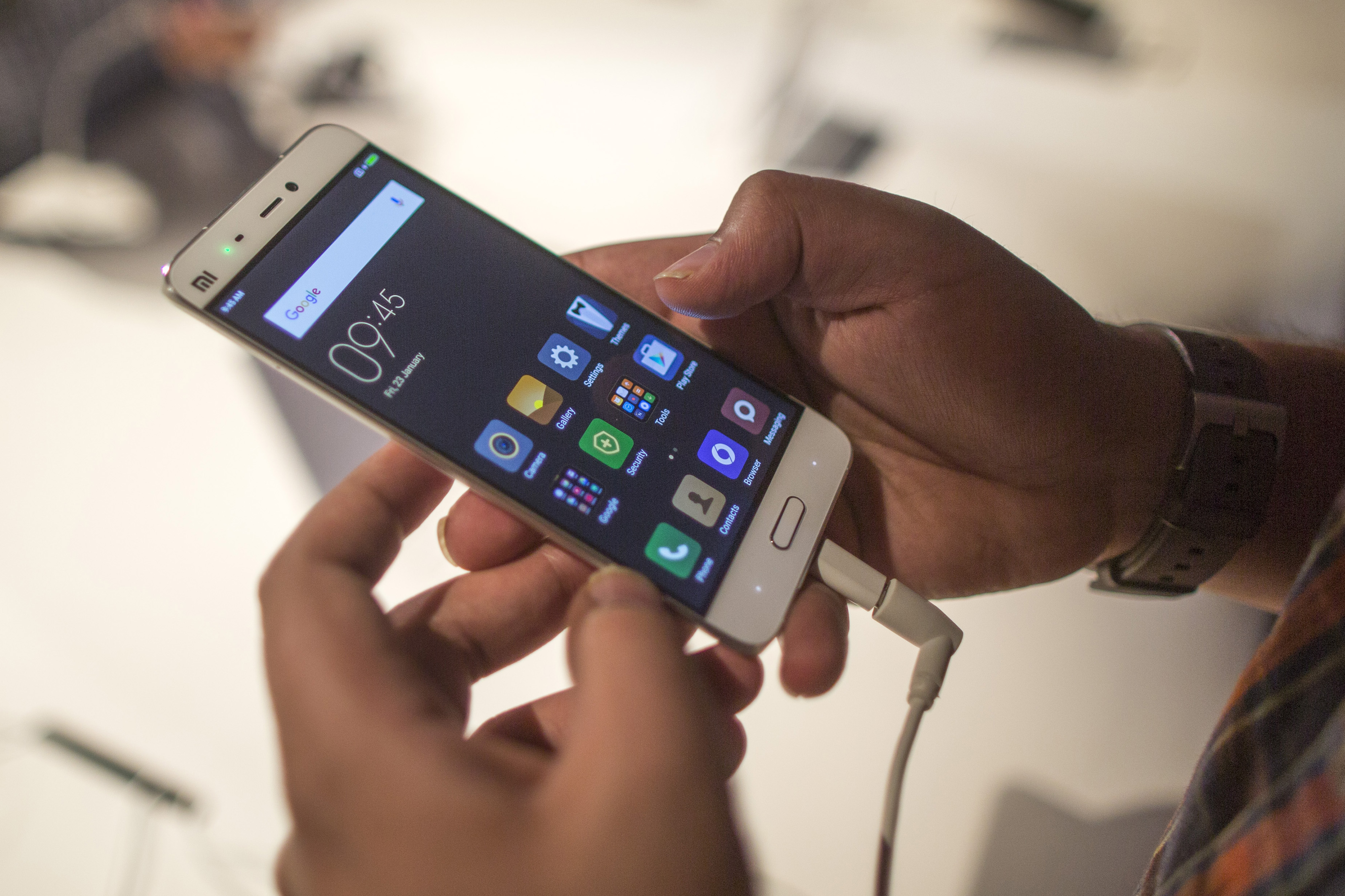 An attendee inspects a Xiaomi Corp. Mi 5 smartphone during a launch event in New Delhi, India, on Thursday, March 31, 2016. (Bloomberg via Getty Images)