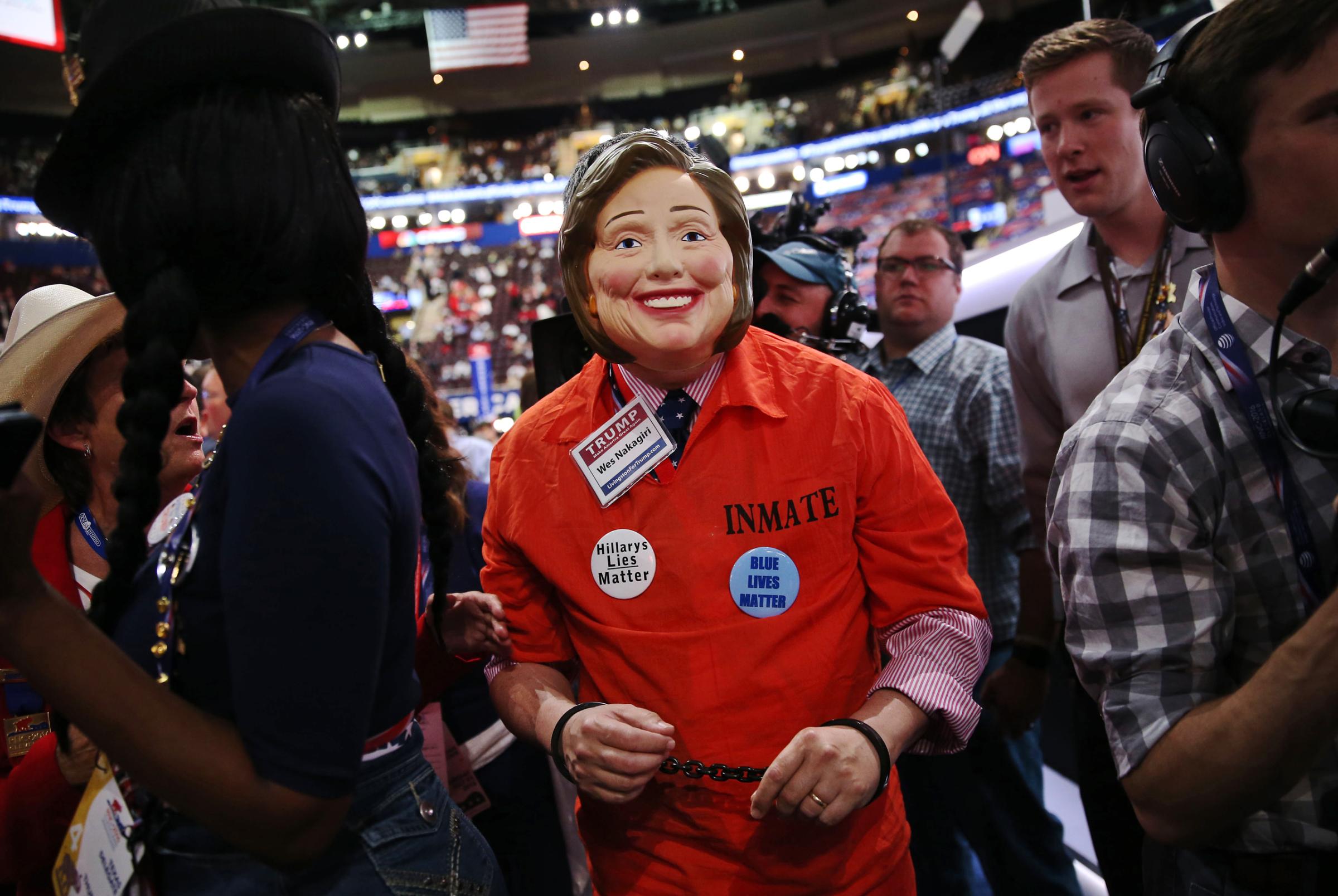 An attendee wears an inmate costume and mask in the likeness of Hillary Clinton during the Republican National Convention (RNC) in Cleveland, Ohio, on July 21, 2016.