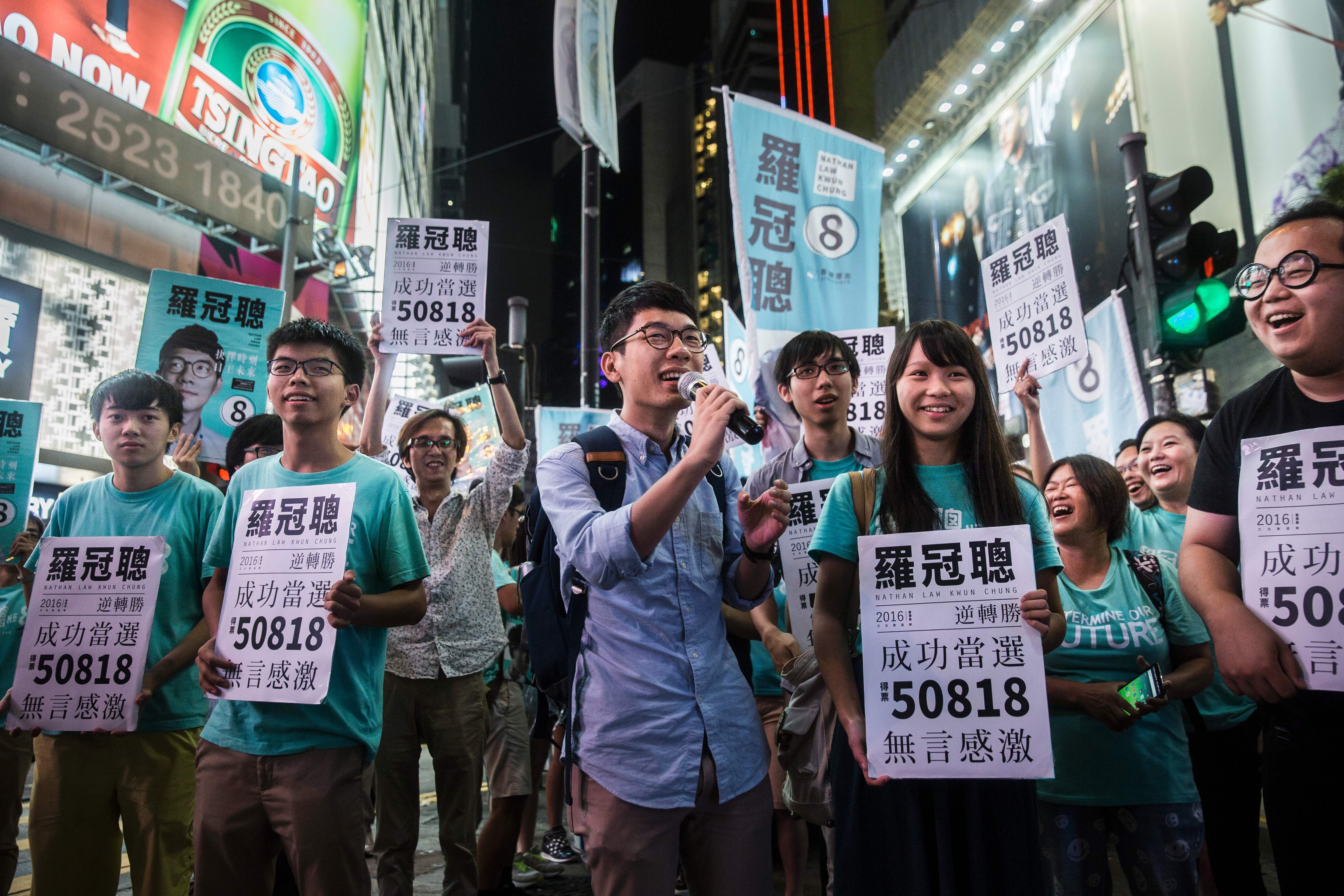 Nathan Law, center, speaks at a rally with pro-democracy activist Joshua Wong, second from left, and supporters in Causeway Bay following Law's win in the Legislative Council election in Hong Kong on Sept. 5, 2016 (Isaac Lawrence—AFP/Getty Images)