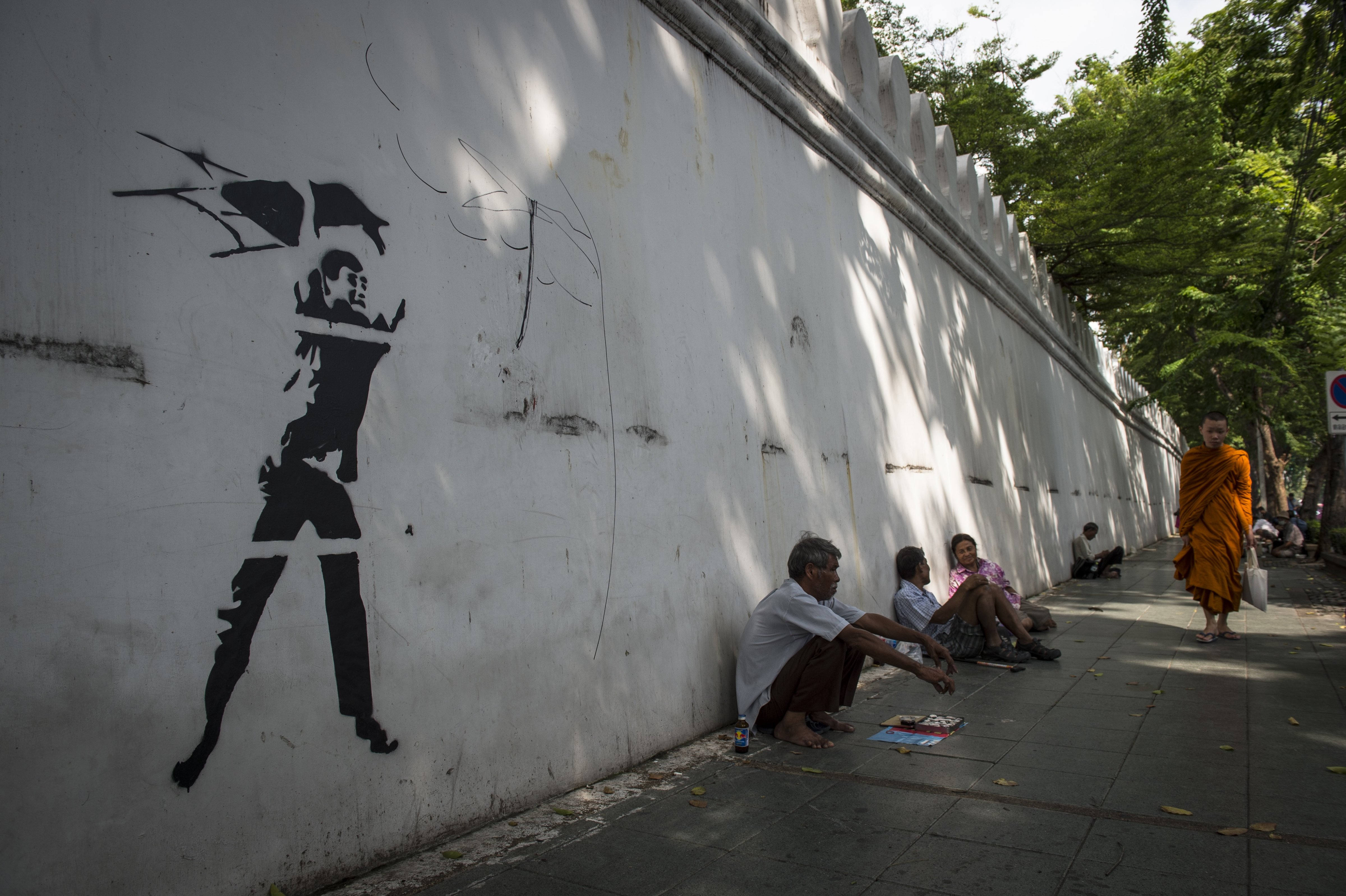 This photo taken on Sept. 30, 2016, shows graffiti depicting a violent ultra-royalist with a chair from the iconic photograph of the Oct. 6, 1976, student massacre by Associated Press photographer Neil Ulevich, on the outside wall of Thammasat University in Bangkok (Lillian Suwanrumpha—AFP/Getty Images)