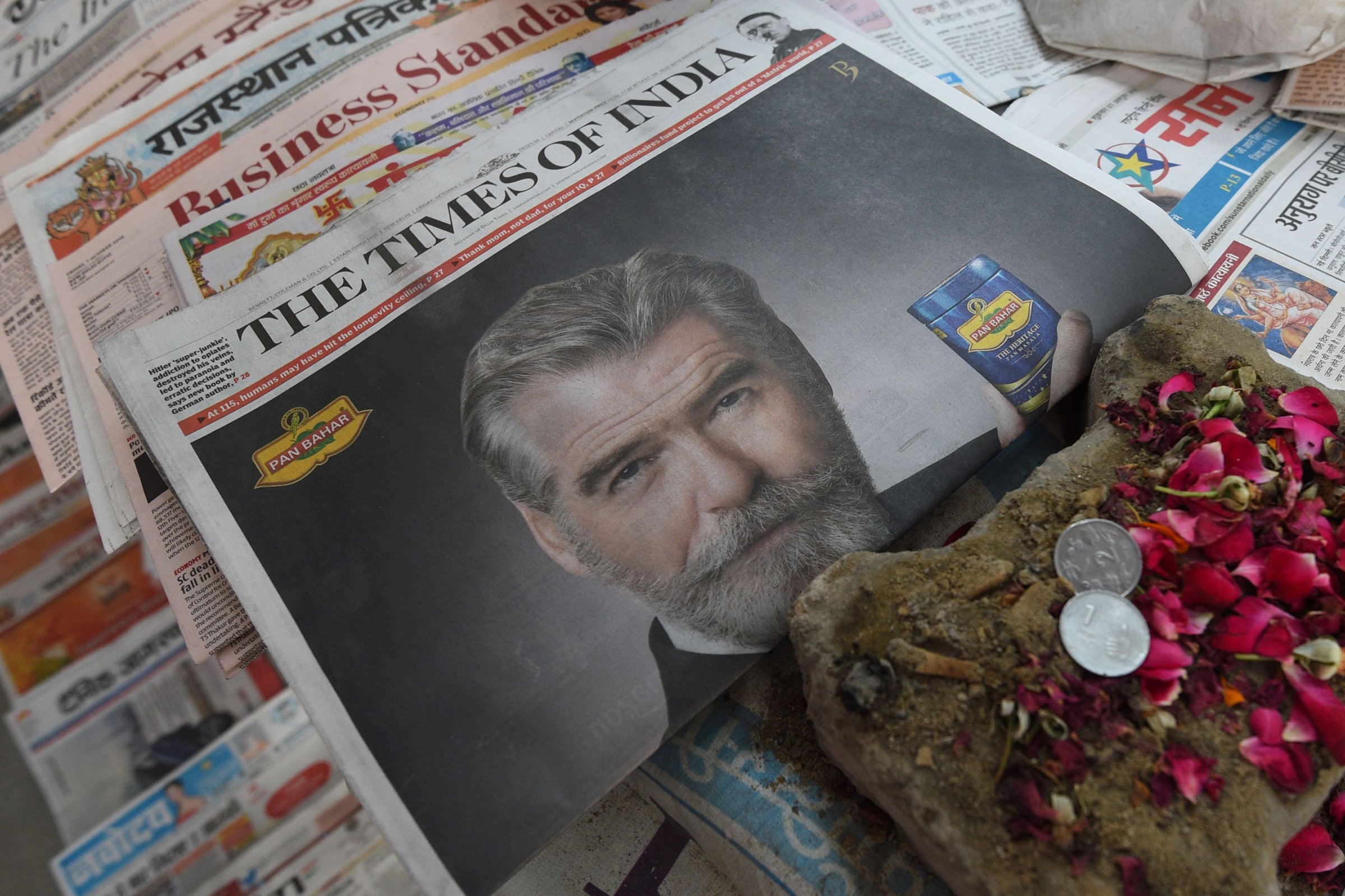 A newspaper with a front page advertisement of Pierce Brosnan endorsing an Indian mouth freshener, is seen on the streets of New Delhi on Oct. 7, 2016.