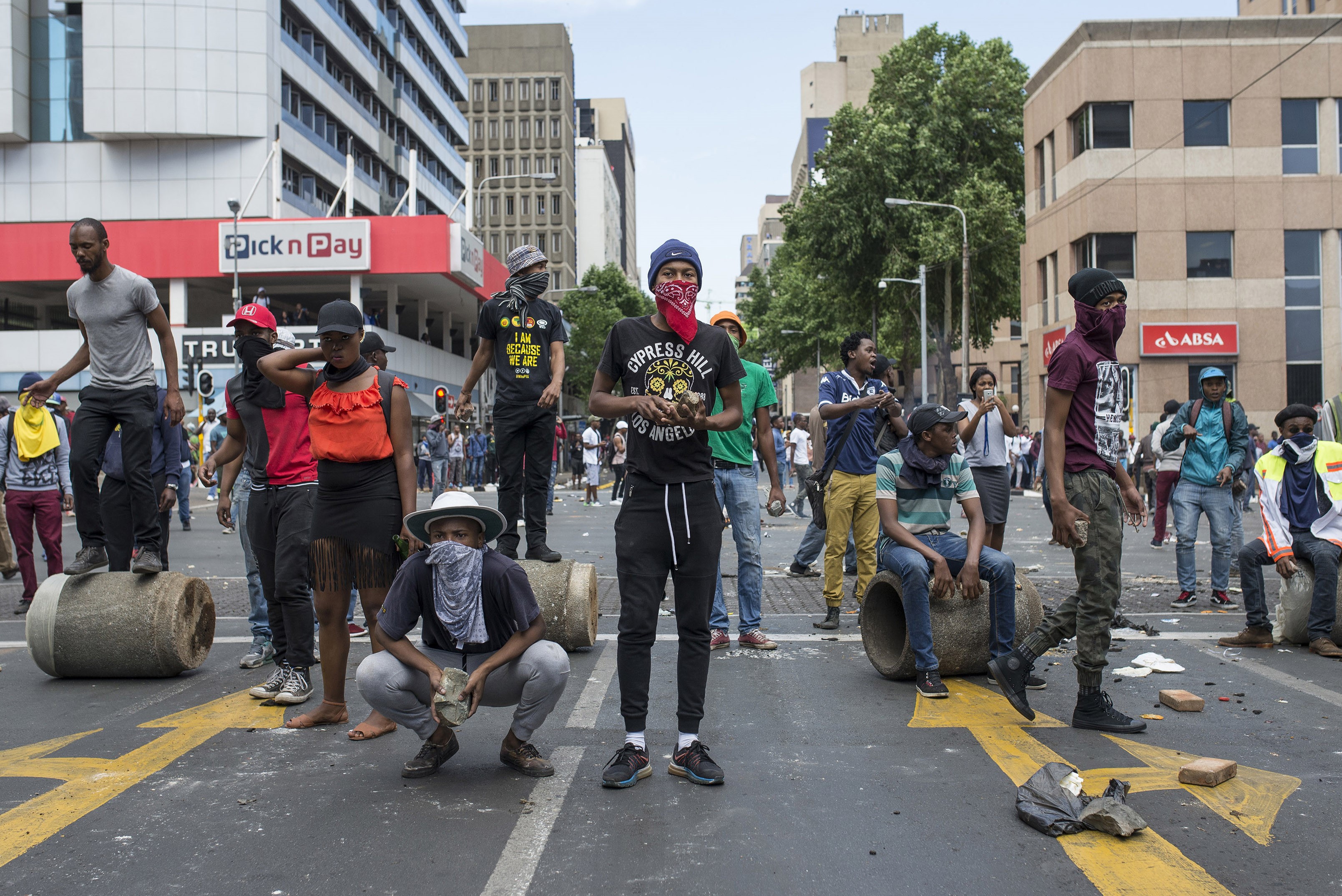 A group of students take cover as the clashes between students and riot police continues during a protest over government's plan of increasing university tuition fees on Oct. 10, 2016 in Witwatersrand University, Johannesburg. (Anadolu Agency/Getty Images)