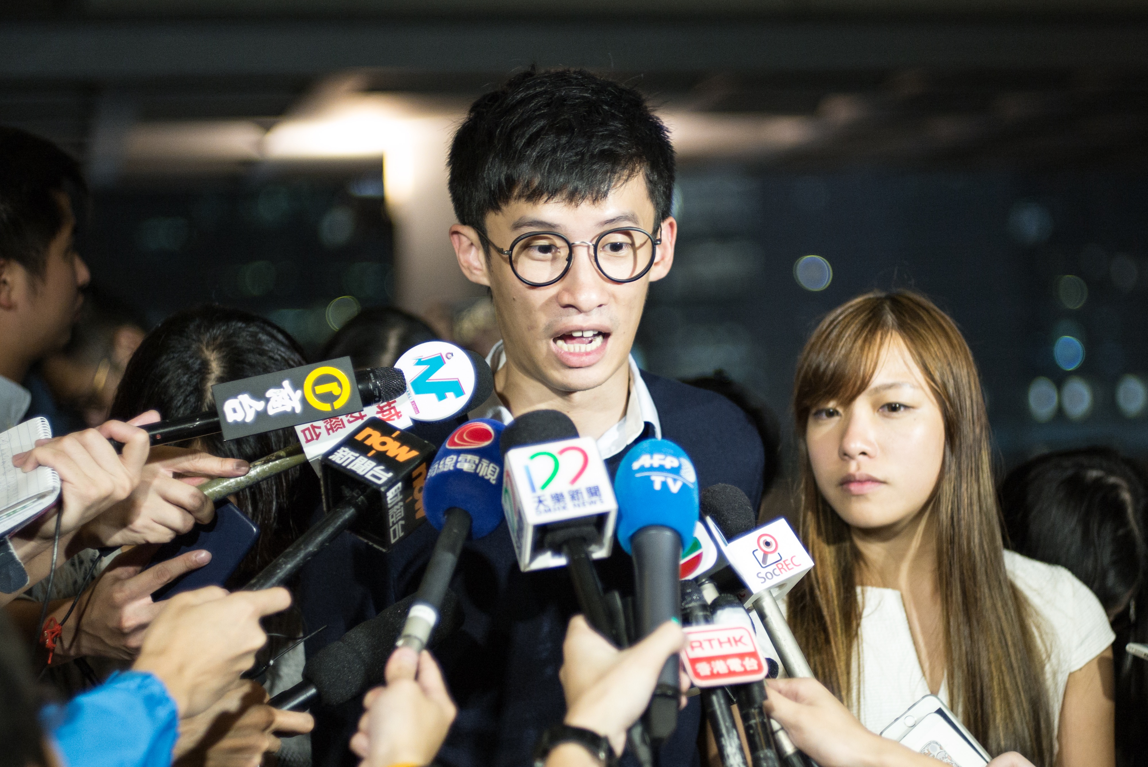 Newly-elected pro-independence Hong Kong lawmakers Sixtus "Baggio" Leung (C) and Yau Wai-ching (R) speak to the press outside the territory's High Court, Oct. 18, 2016. (Aaron Tam/AFP/Getty Images)