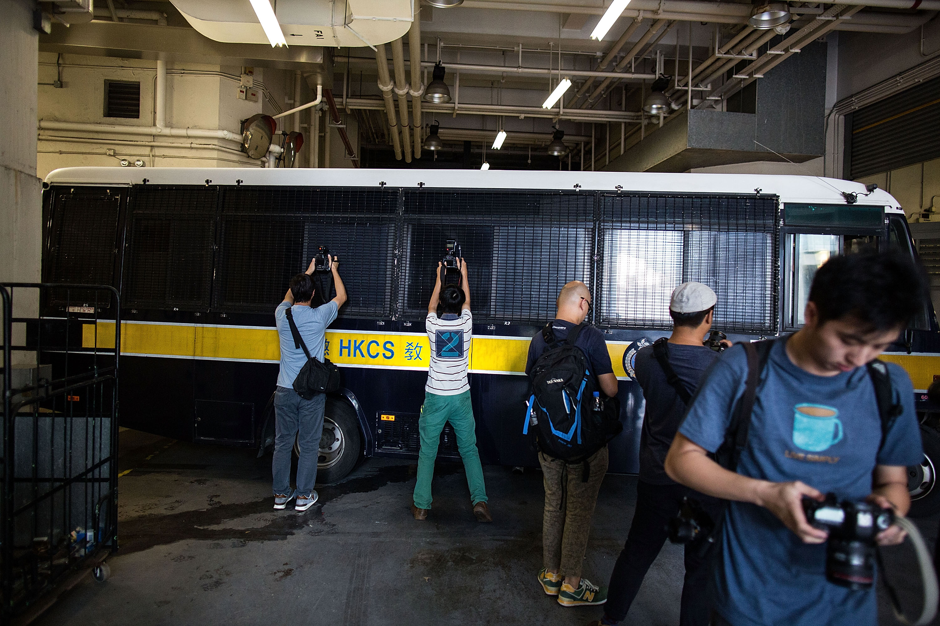 Journalists take photographs when a prison vehicle escorting Rurik Jutting leaves the High Court on Oct. 24, 2016, in Hong Kong (Lam Yik Fei—Getty Images)