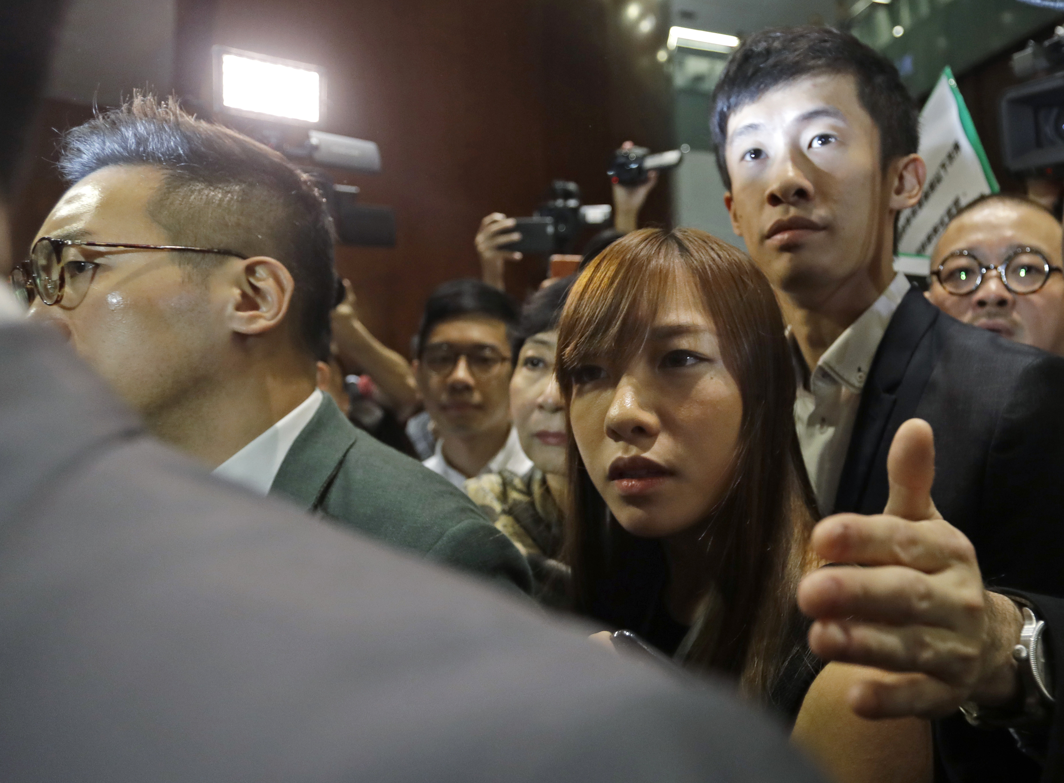 Hong Kong lawmakers Yau Wai-ching, center, and Sixtus Leung, right, are escorted by pan-democrats to enter the legislative chamber in Hong Kong on Oct. 26, 2016. More unruly scenes have erupted at Hong Kong’s Legislative Council as the two newly elected lawmakers defied an order barring them from retaking their oaths after being disqualified earlier for swearing allegiance to the "Hong Kong nation" (Kin Cheung—AP)