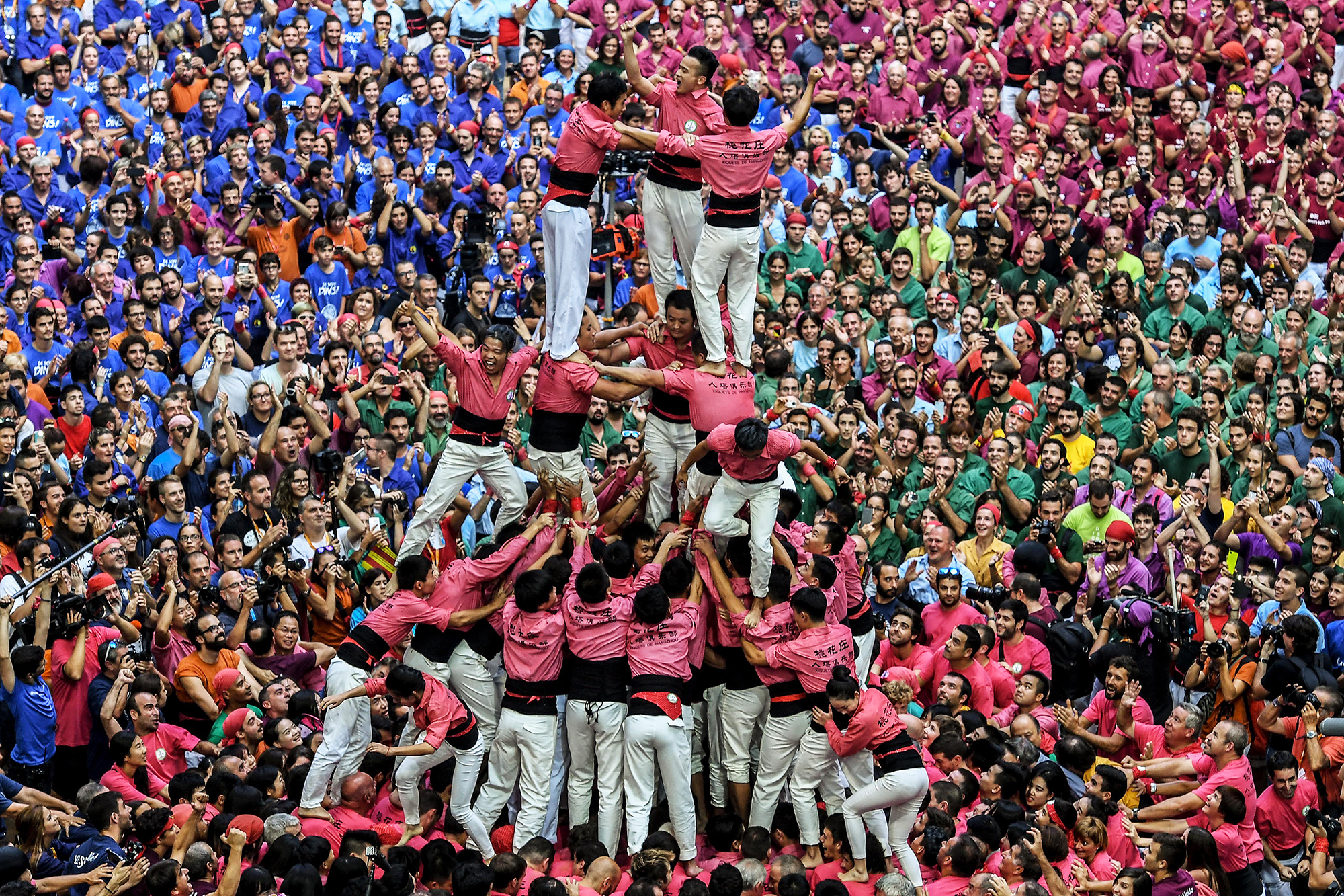 Members of the colla 'Xiquets de Hanghzou' celebrate after building a human tower in Tarragona, Spain, on Oct. 1, 2016.