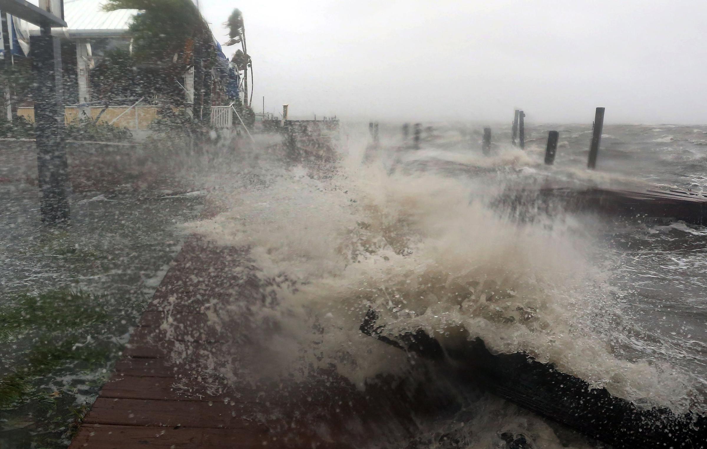 Surf from the Banana River crashes up on a dock at Sunset Grill in Cocoa Beach, Fla., as Hurricane Matthew hits Florida's east coast, Oct. 7, 2016.