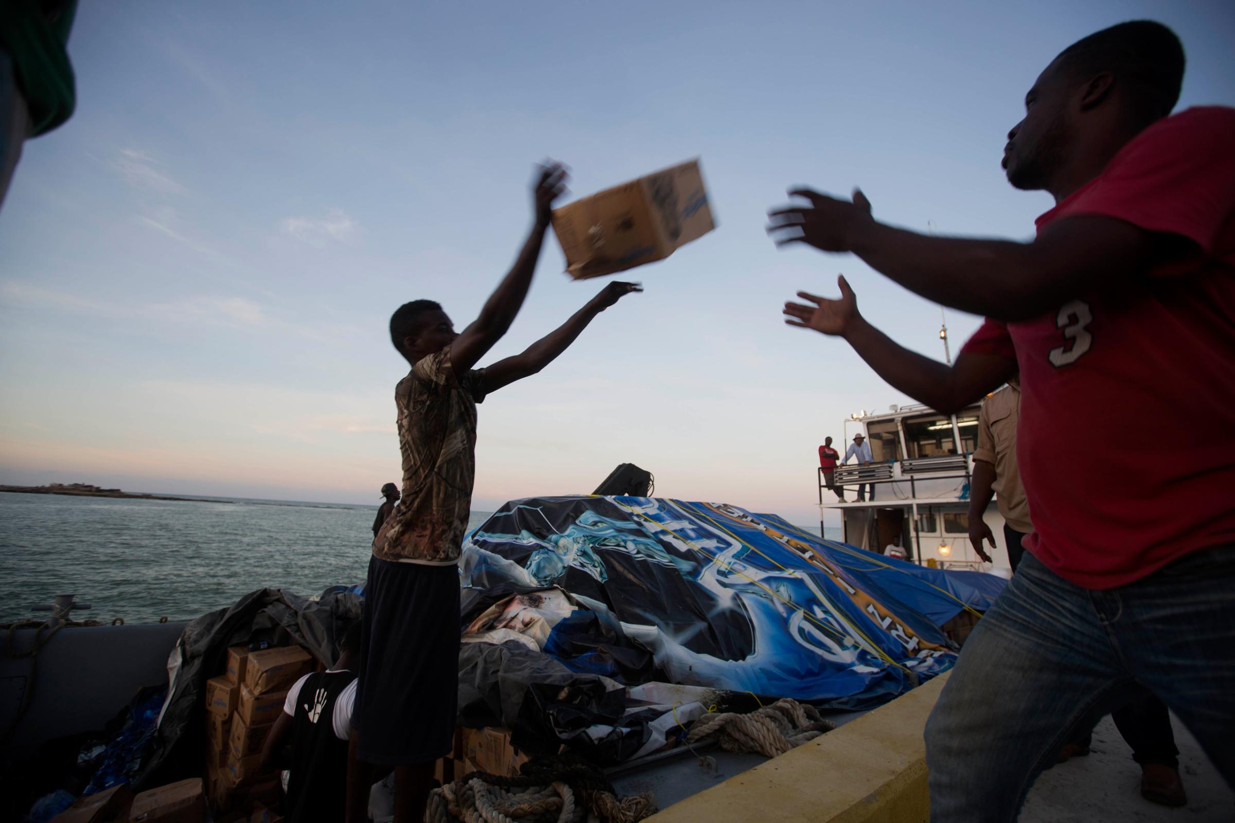 People unload food and water boated in from the "Mission of Hope" charity after Hurricane Matthew swept through Jeremie, Haiti, Saturday, Oct. 8, 2016. Jeremie appears to be the epicenter of the country's growing humanitarian crisis in the wake of the storm. (AP Photo/Dieu Nalio Chery)
