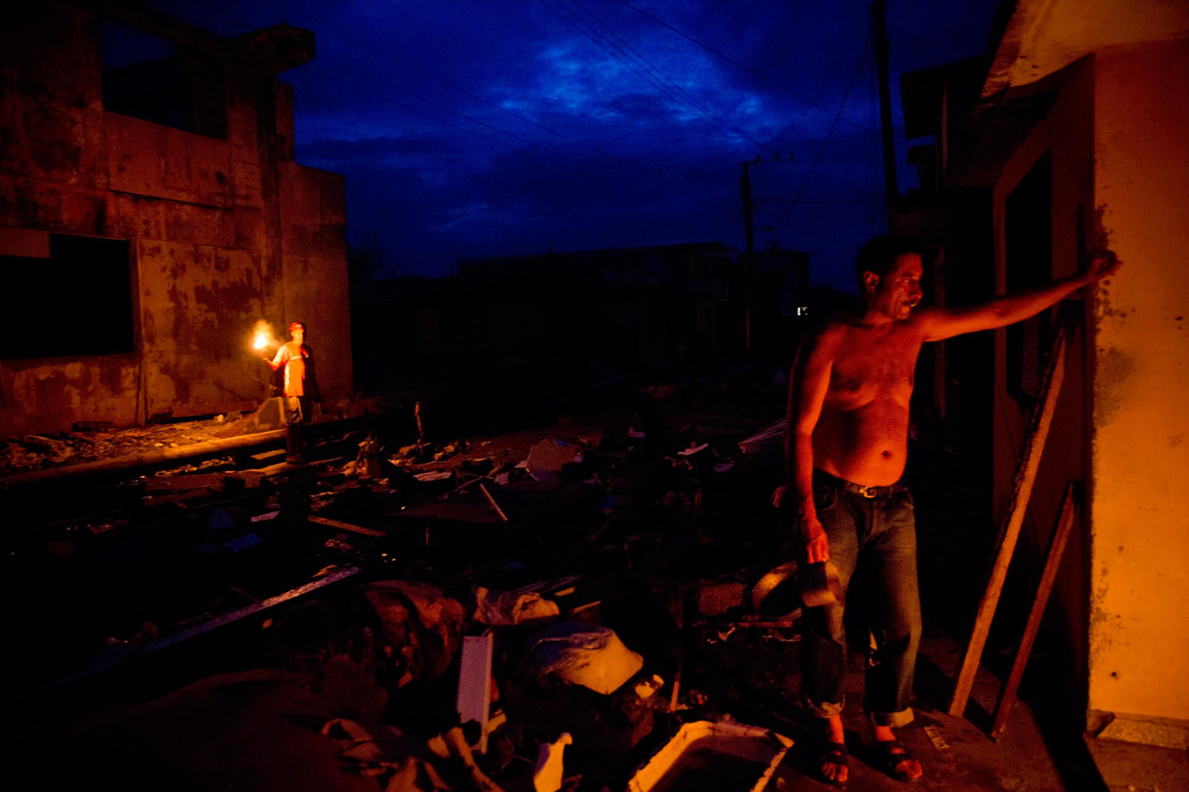 Jorge Luis Azahares, 52, waits for his wife to arrive with food, amid the ruins of his home destroyed by Hurricane Matthew, in Baracoa, Cuba, Thursday, Oct. 6, 2016. Matthew hit Cuba's lightly populated eastern tip Tuesday night, damaging hundreds of homes in the easternmost city of Baracoa but there were no reports of deaths. Nearly 380,000 people were evacuated and measures were taken to protect infrastructure. (AP Photo/Ramon Espinosa)