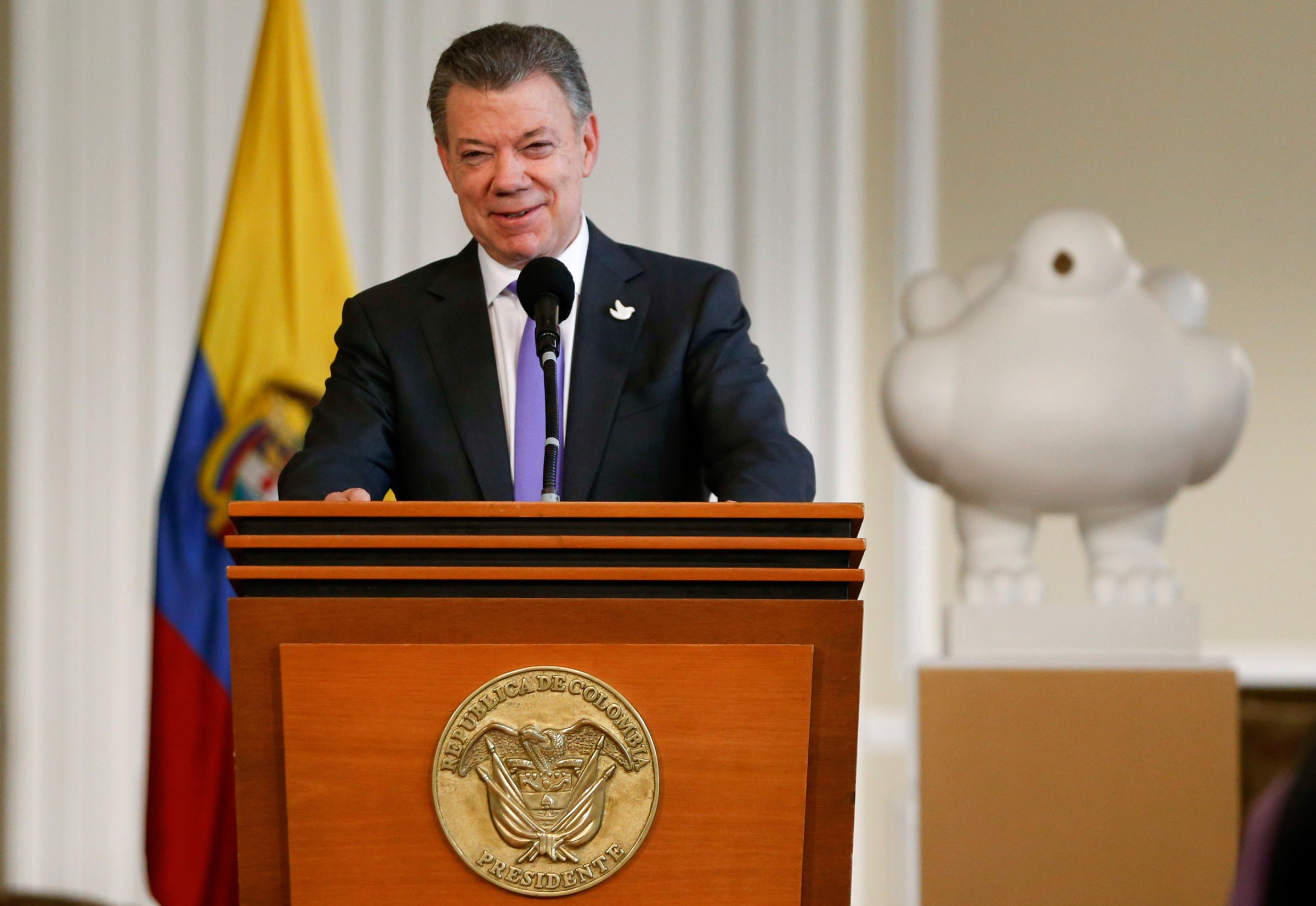 Colombia's President Juan Manuel Santos speaks to supporters of the peace deal he signed with rebels of the Revolutionary Armed Forces of Colombia, FARC, at the presidential palace in Bogota, Colombia, Friday, Oct. 7, 2016, behind a sculpture of a white dove donated by Colombian artist Fernando Botero. Santos won the Nobel Peace Prize Friday, just days after voters narrowly rejected a peace deal. (AP Photo/Fernando Vergara)