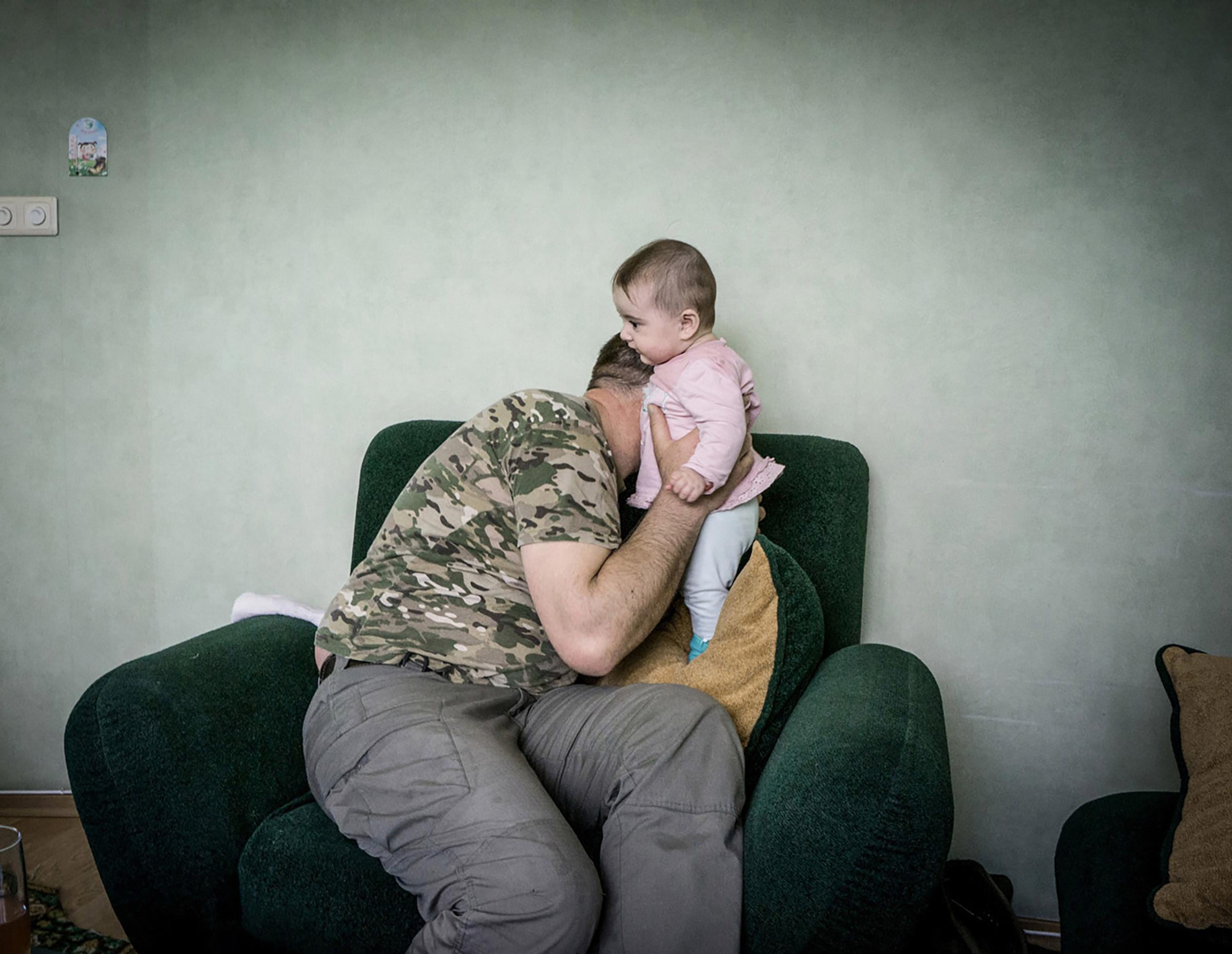 David Ebralidze with his daughter .Julia Tarasova moved to Ukraine 15 years ago from Murmansk, Russia. She supported both the Orange and Maidan Revolutions and became David’s partner in 2013. David volunteered to fight separatists in 2014 and was granted Ukrainian citizenship as a result. David and Julia are two protagonists from my project that I have been following for two years.From an interview with Julia:“I never thought I would bid farewell to man going to war. Before, we watched Soviet movies about World War II, where women in headscarfs bid farewell to their men. We watched them as kids, thinking they were part of history that would never repeat. I have bid farewell to David three or four times more… The first time it is hard, then you get used to it. But still each time is like the last time (…) When he was a freed from prisoner of war, I met him on the road from Donetsk to Dniepropetrovsk. The whole way I imagined how I would greet him, jump on him and embrace him…but when he came, it was a different person that met me. Outside it was him, but inside it was a stranger… The body cannot deceive you, I couldn’t pretend, I wasn’t able to compose myself. I was happy he was alive but a different person was standing in front of me.”