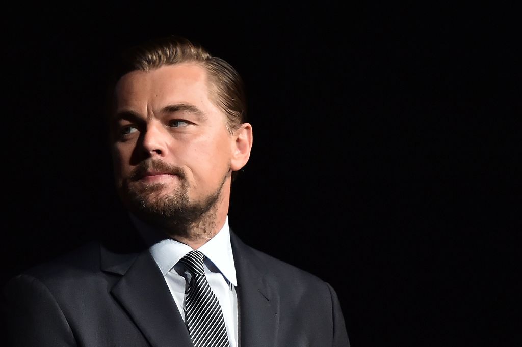 Leonardo DiCaprio looks on prior to speaking on stage during the Paris premiere of the documentary film 