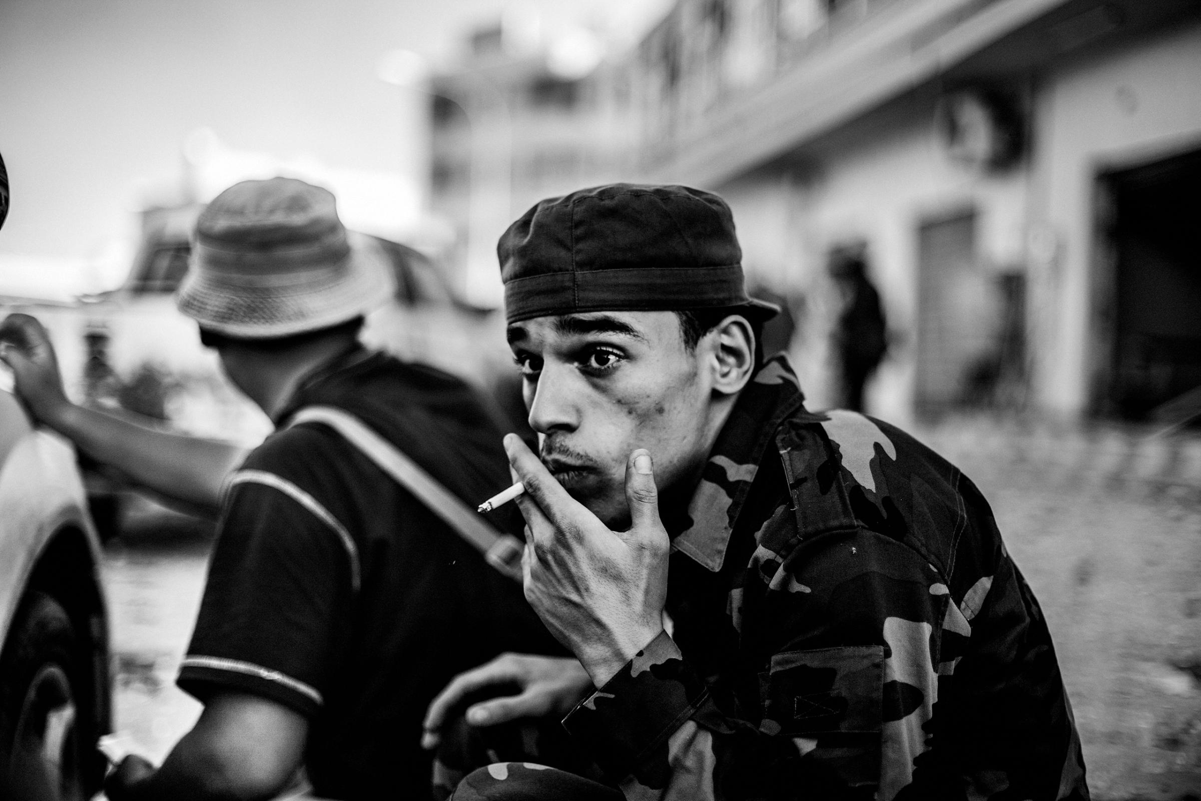 A revolutionary fighter seeks shelter from sniper fire by forces loyal to Muammar Gaddafi, Sirte, Libya, Oct. 12, 2011.