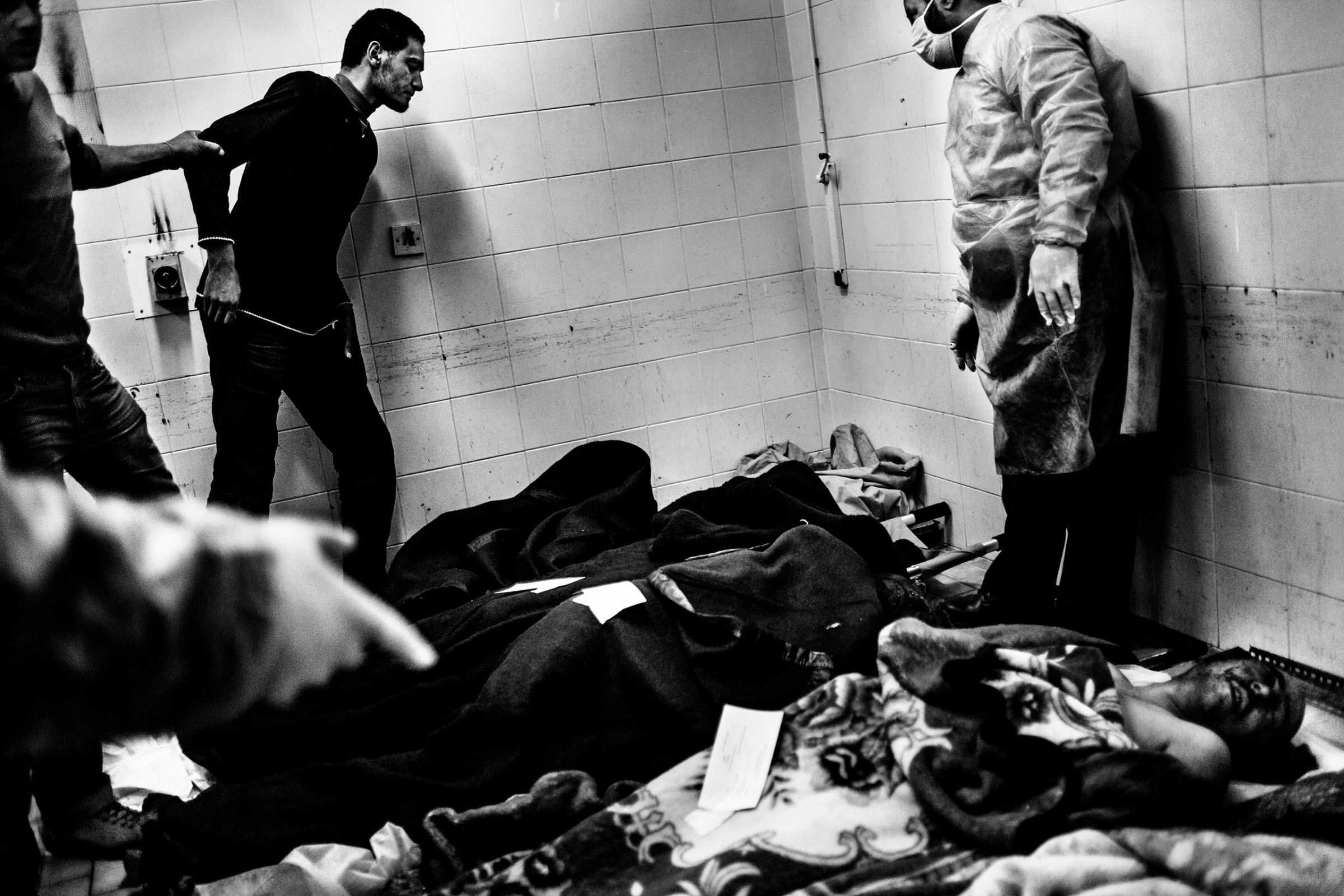 The relative of a victim approaches the body of a revolutionary fighter to recognize if it's its loved one. The victims are killed during the fighting against Gaddafi's forces on March 4, 2011.  Benghazi, Libya.