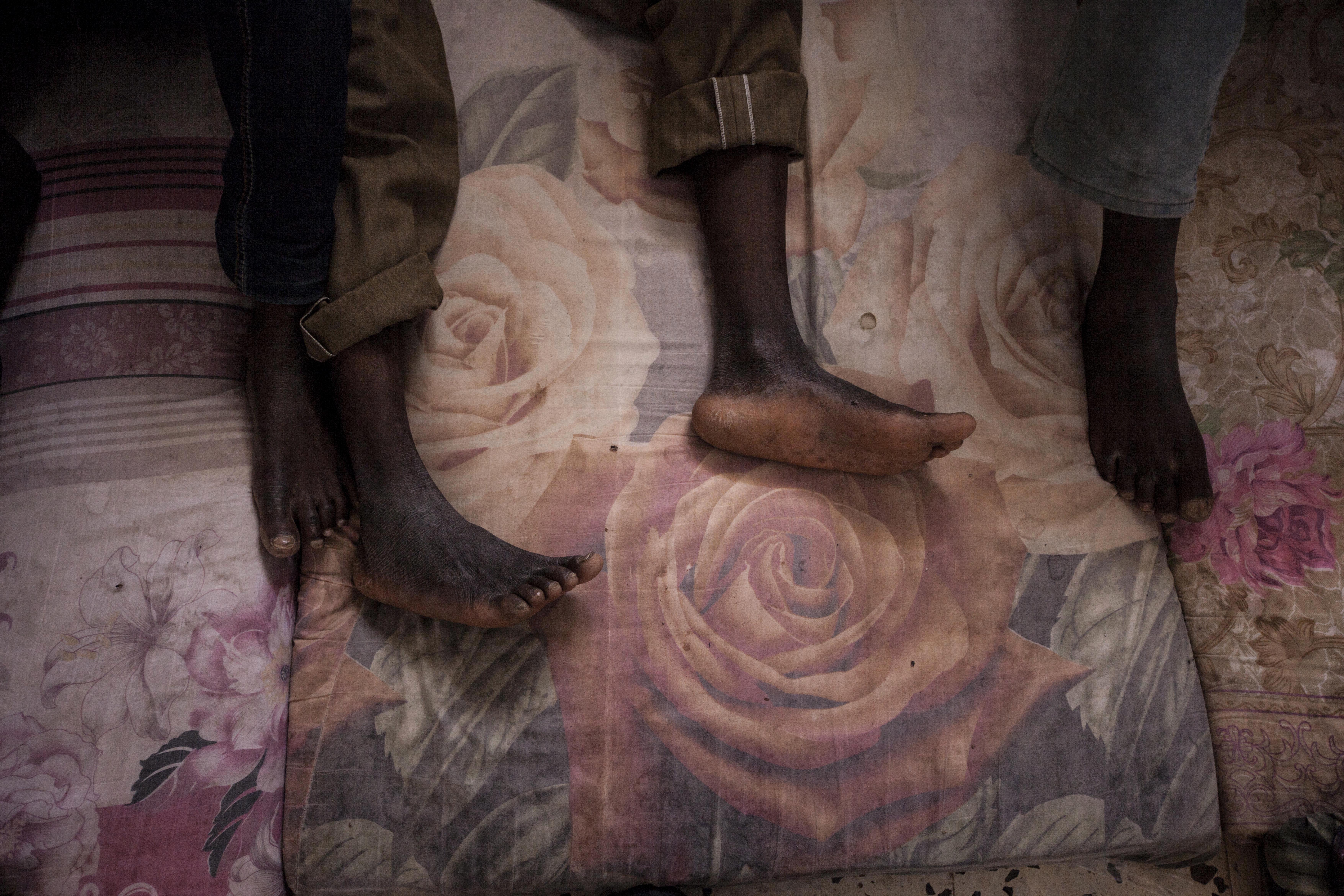 Migrants rest on mattresses in the male section of a detention center in Surman, Libya.