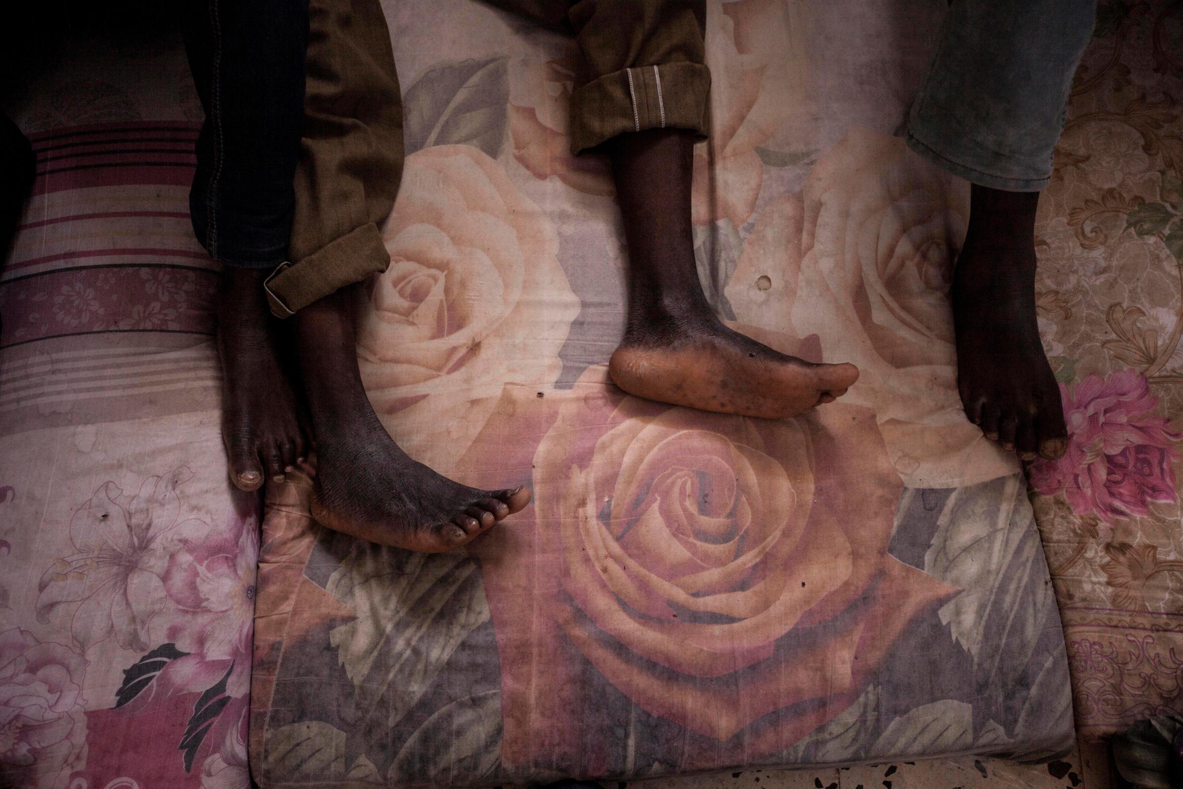 Migrants rest on mattresses in the male section of a detention center in Surman, Libya.