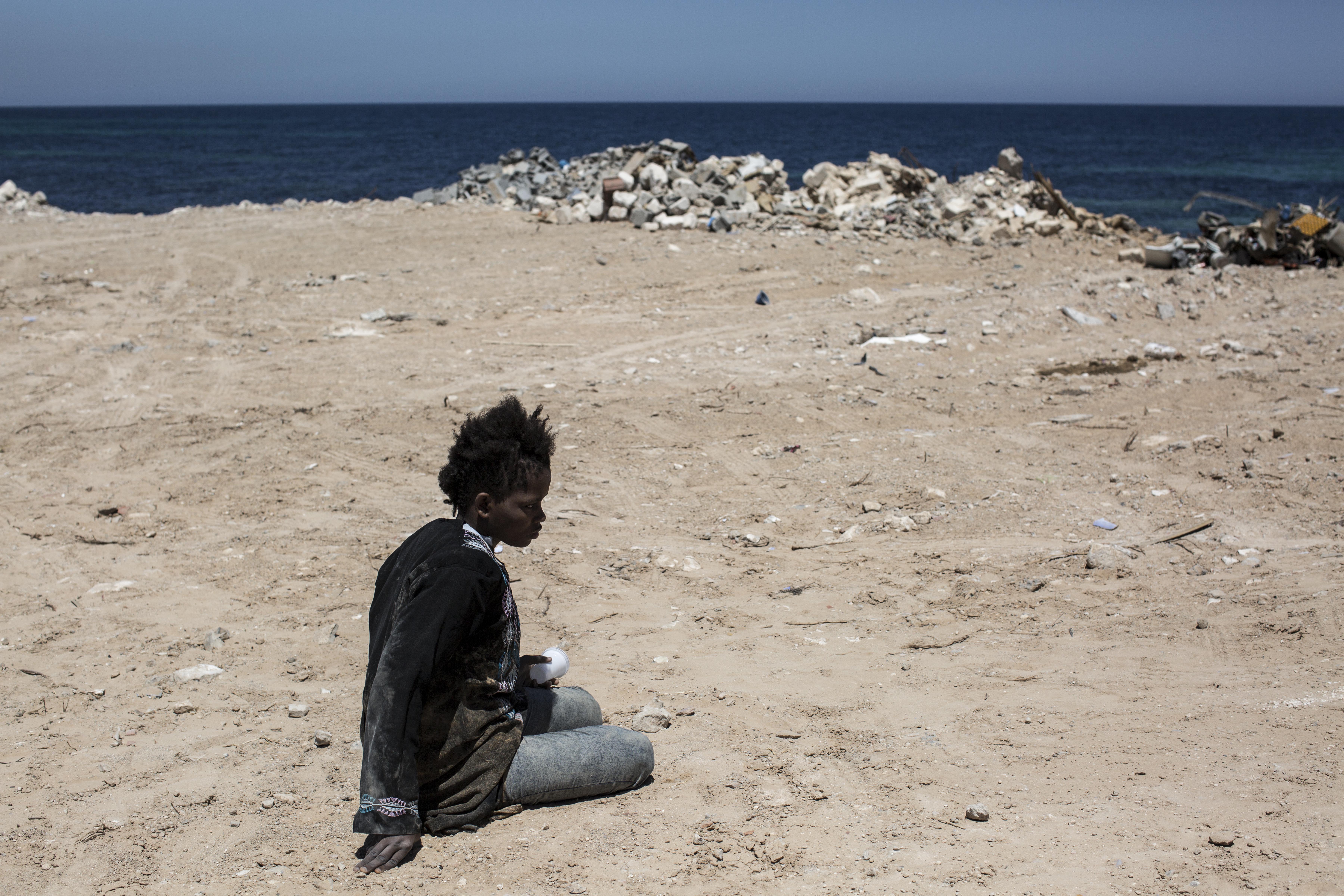 A migrant waits after she was arrested by Libyan coastguards on the Mediterranean Sea near Tajoura, Libya.