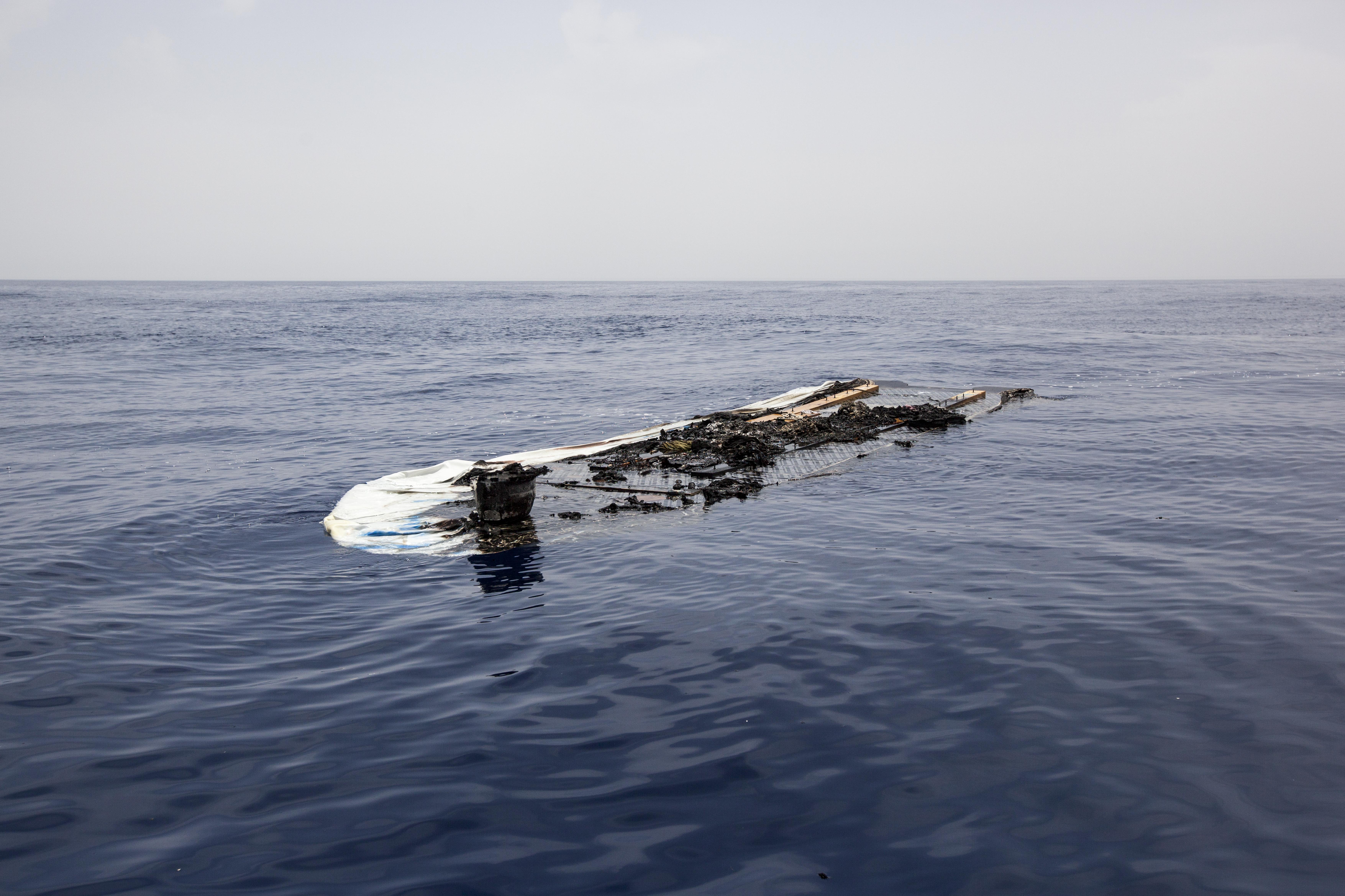 What remains of a rubber boat floats in the Mediterranean Sea after having been set ablaze.