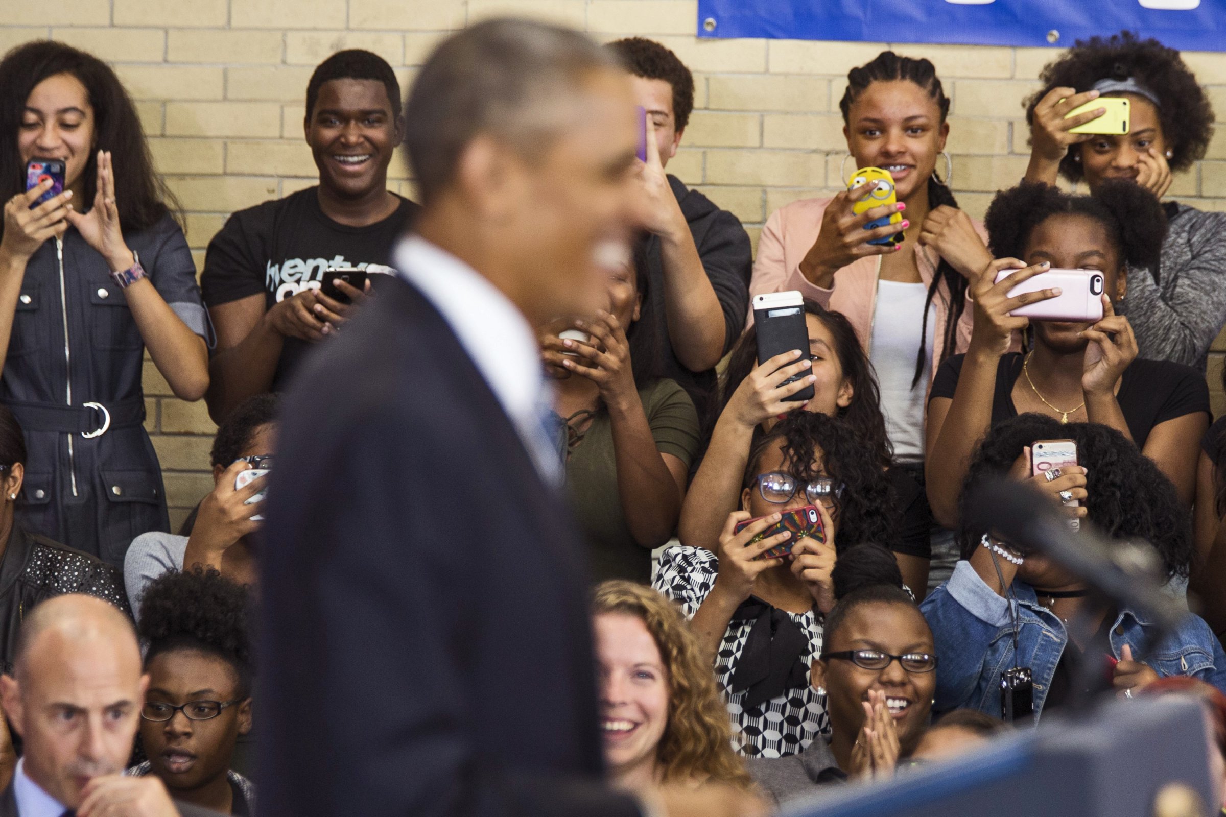 Obama smiles as students take photos on their cell phones during a speech at Benjamin Banneker Academy High School in Washington, on Oct. 17, 2016.