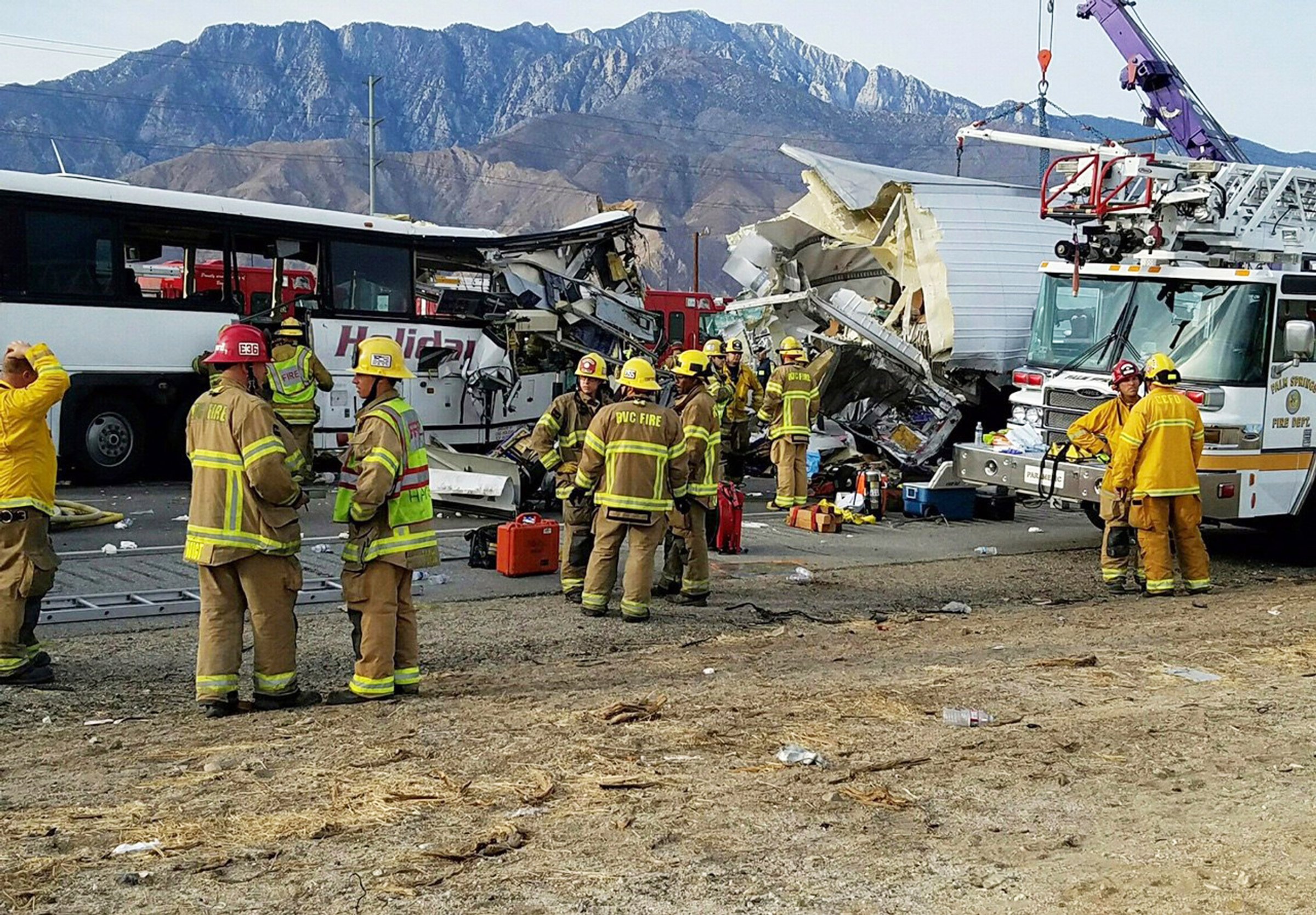 This photo provided by KMIR-TV shows the scene of crash between a tour bus and a semi-truck crashed on Interstate 10 near Desert Hot Springs, near Palm Springs, in California's Mojave Desert Sunday, Oct. 23, 2016. Multiple deaths and injuries were reported. (KMIR-TV via AP)