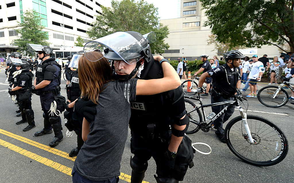 A woman hugs a police officer outside Bank of America Stadium on Sept. 25, 2016 in Charlotte, N.C.