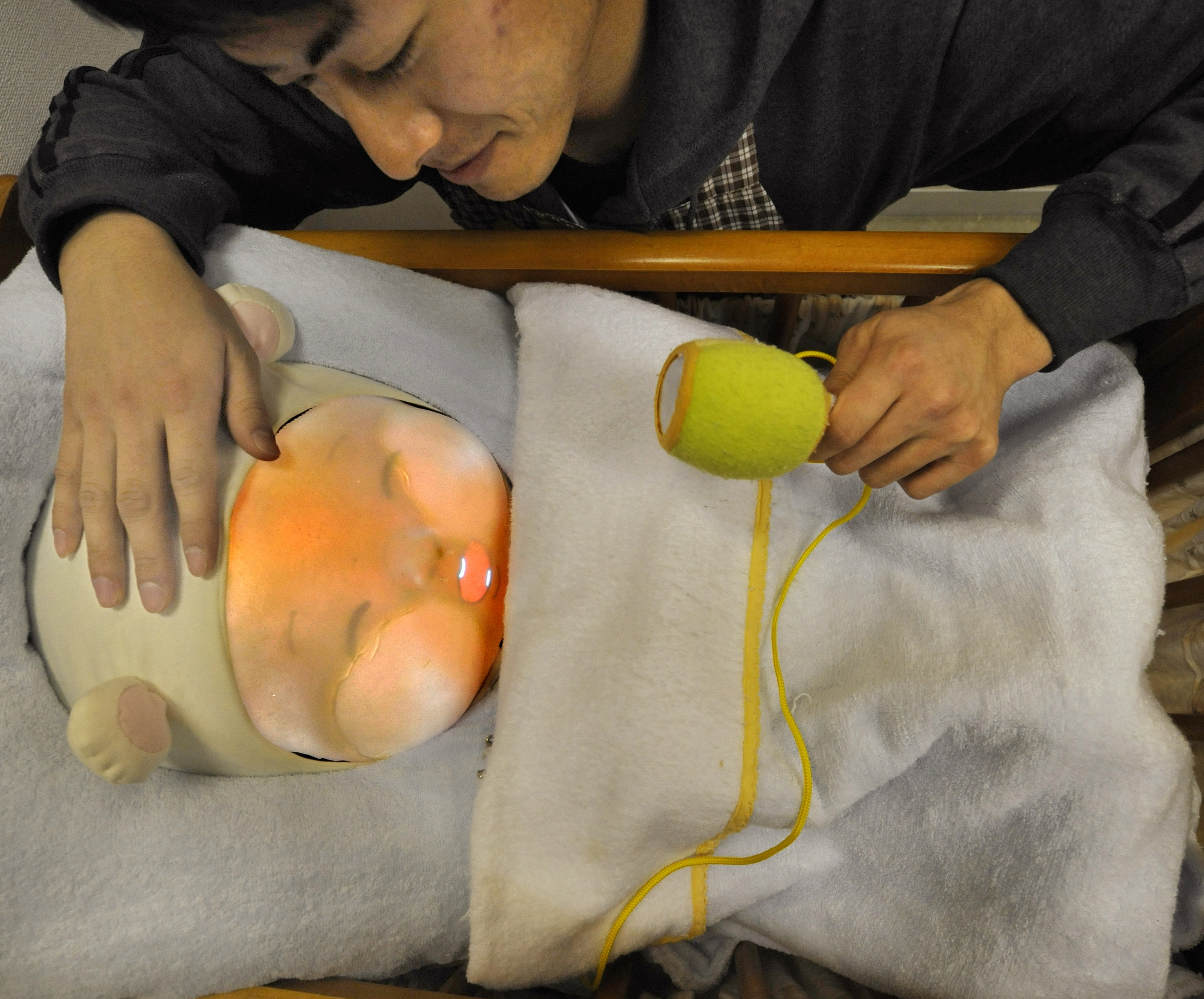 Tamura An engineering student soothes a baby robot during a presentations at a lboratory in Tsukuba University, Ibaraki Prefecture on February 12, 2010. (KAZUHIRO NOGI—AFP/Getty Images)