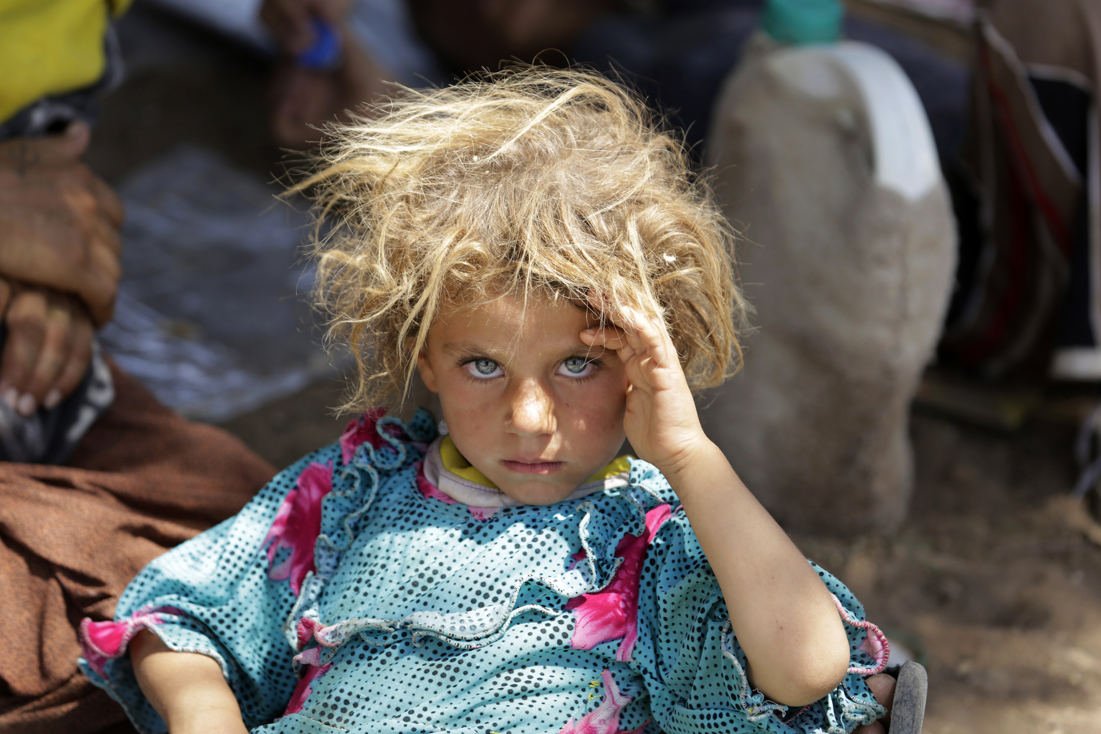 A girl from the minority Yazidi sect, fleeing the violence in the Iraqi town of Sinjar, rests at the Iraqi-Syrian border crossing in Fishkhabour