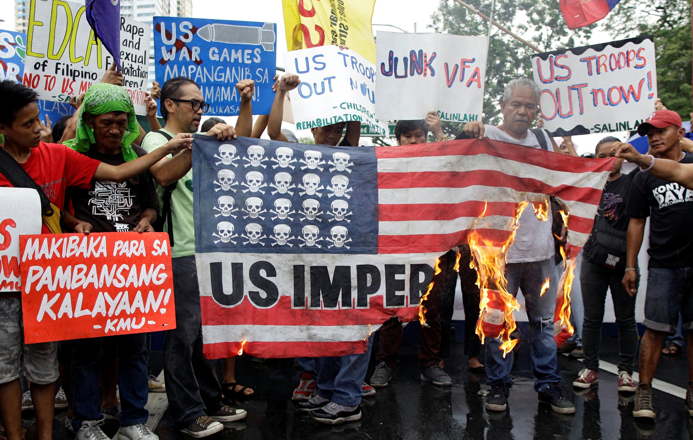 Demonstrators burn a mock U.S. flag during a rally opposing the U.S.-Philippines joint military exercises outside the U.S. embassy in Manila