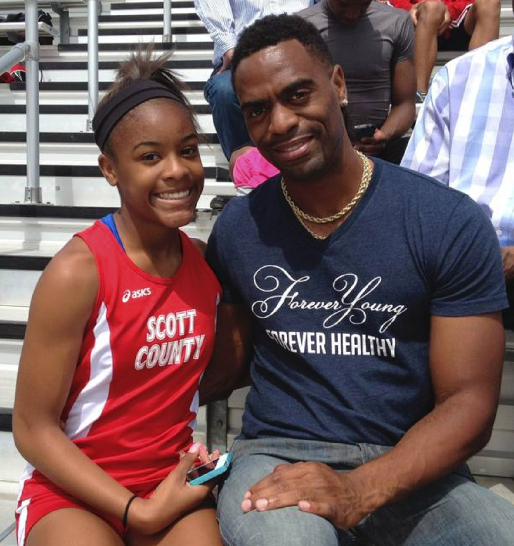 In this May 3, 2014, photo, Trinity Gay, a seventh-grader racing for her Scott County High School team, poses for a photo with her father Tyson Gay, after she won the 100 meters and was part of the winning 4-by-100 and 4-by-200 relays at the meet in Georgetown, Ky. (Mark Maloney/Lexington Herald-Leader—AP)